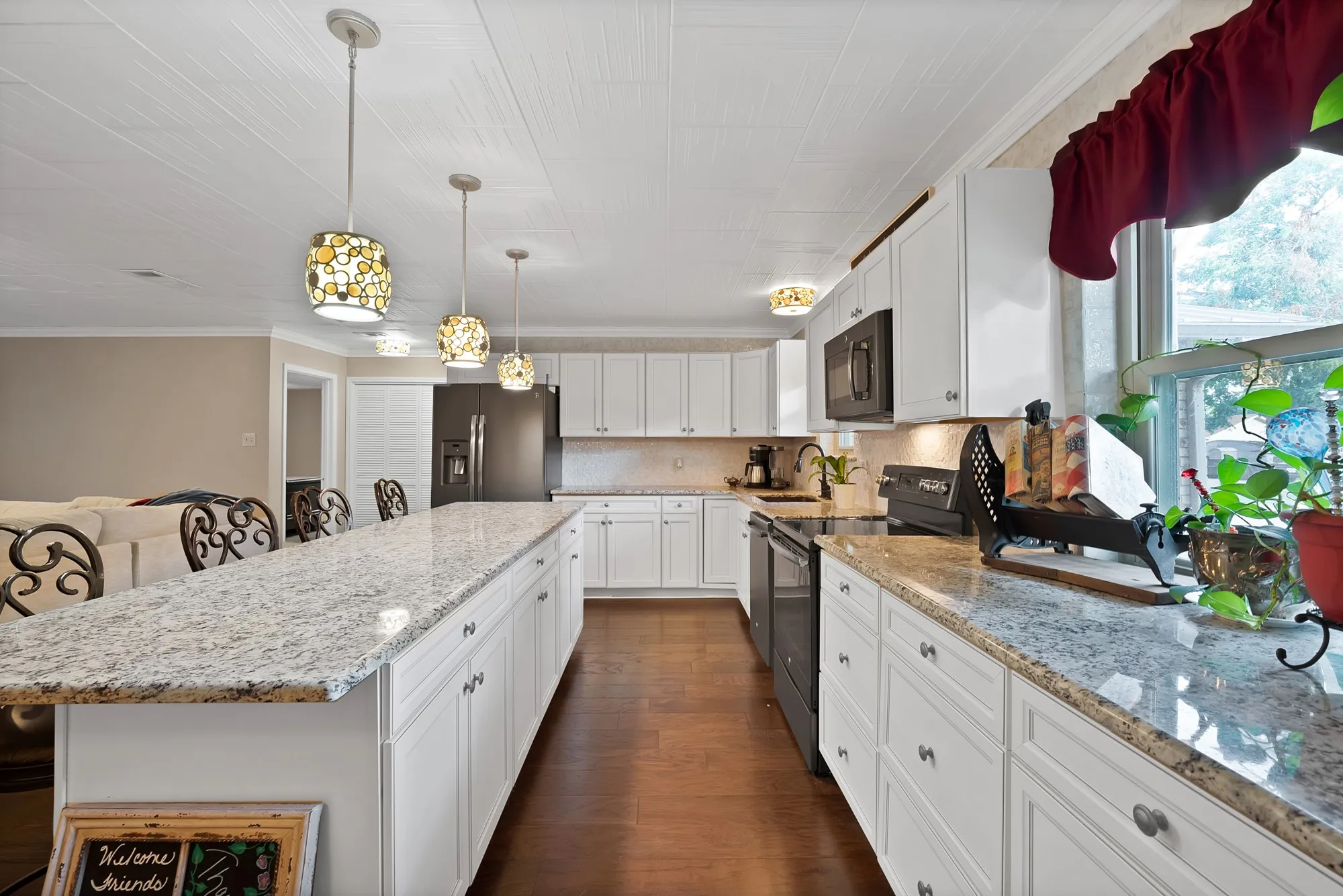 Kitchen featuring white cabinetry, granite countertops, wood-finish flooring, a stainless steel refrigerator, and recessed lighting