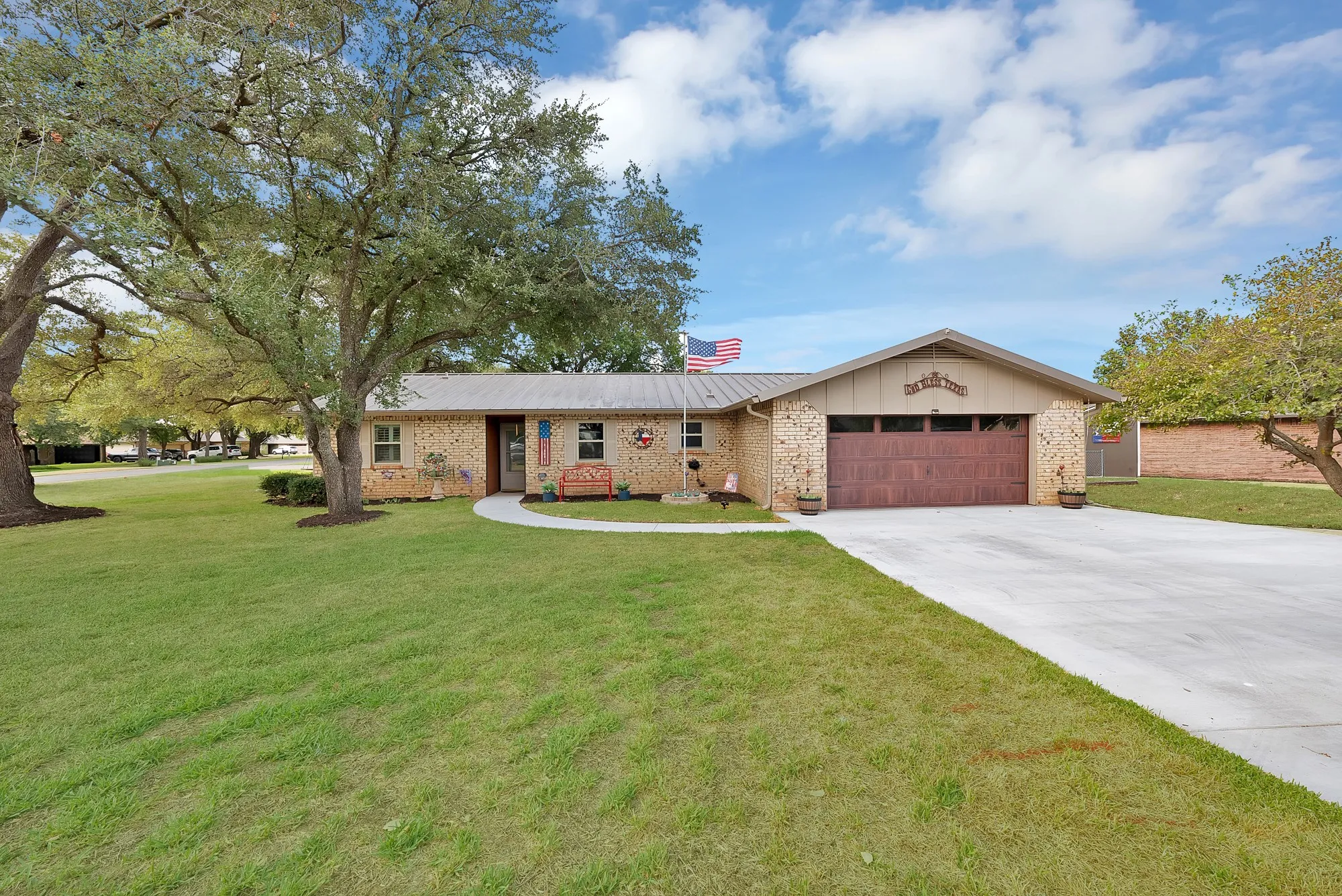 Brick exterior with a metal roof and an attached garage