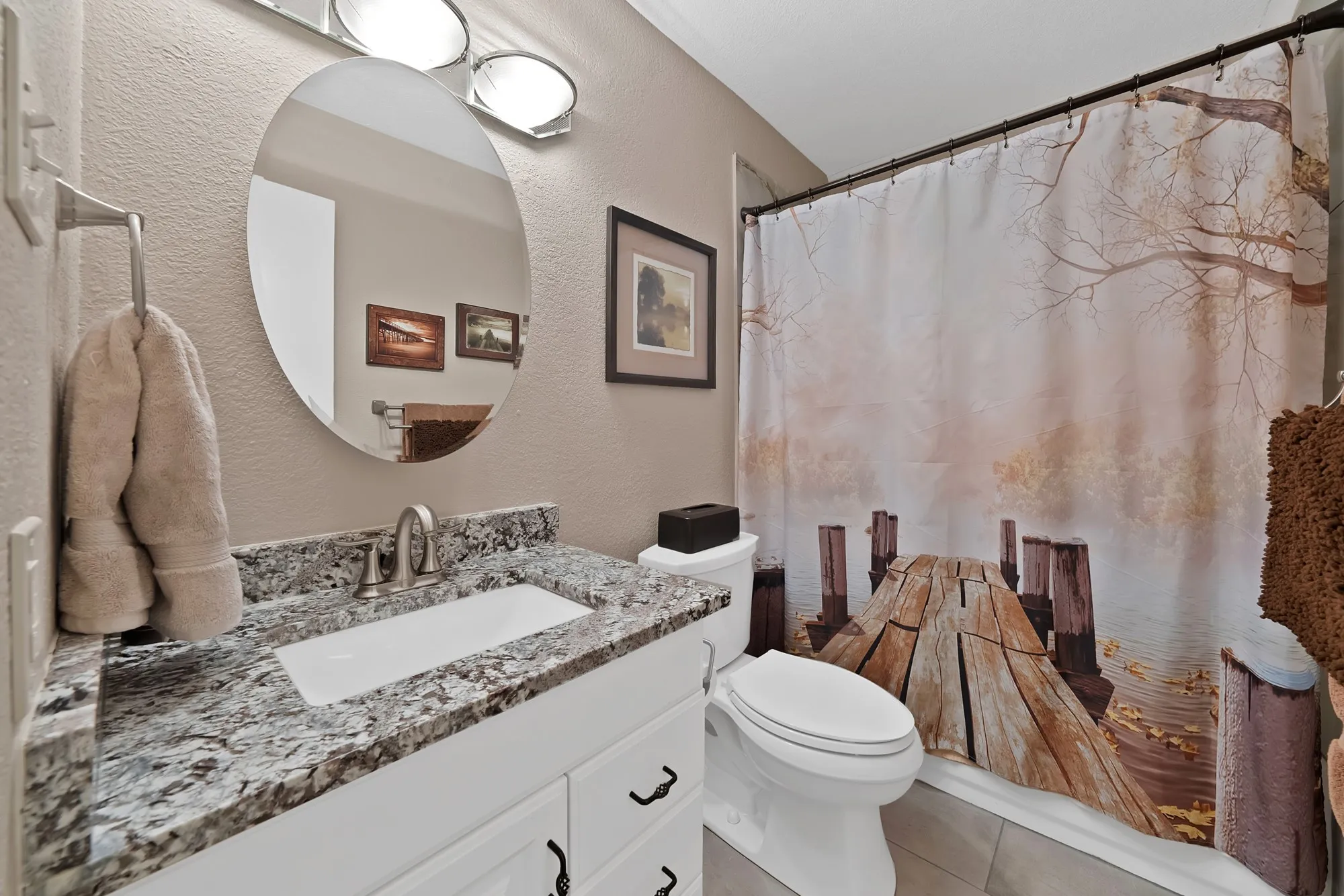 Vanity with a granite countertop, undermount sink, and brushed nickel faucet