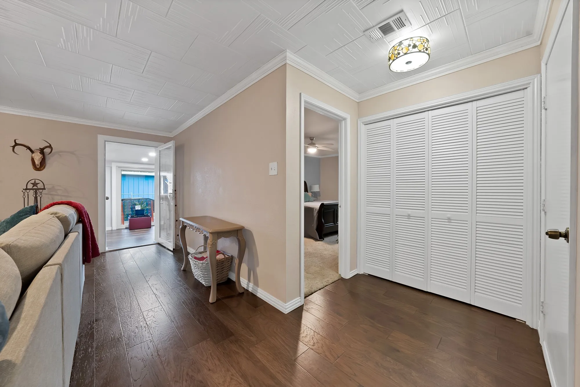 Wood-finish flooring throughout, paired with a white textured ceiling and crown molding