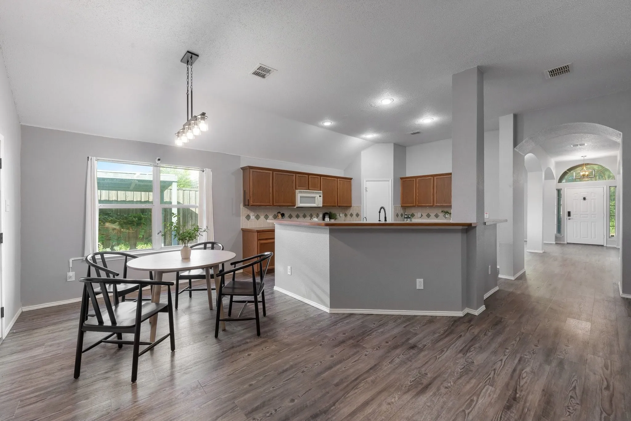 Kitchen and dining area featuring wood-finish flooring, recessed lighting, and a kitchen island with built-in cabinetry