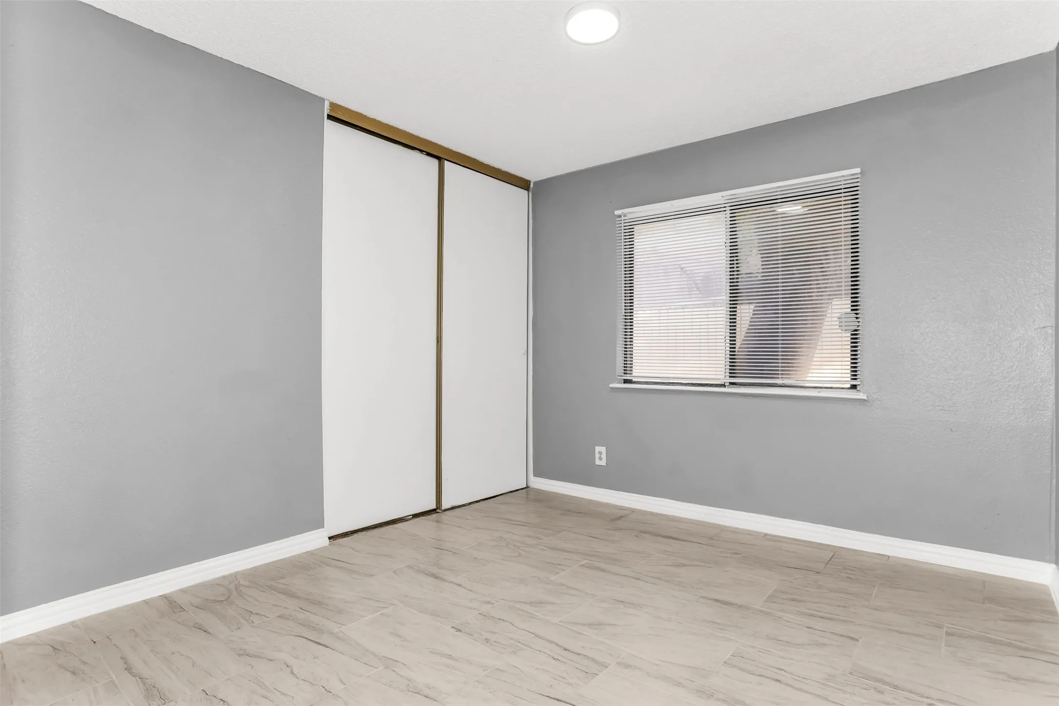 Recessed lighting, wood-finish flooring, sliding closet doors, and a window with blinds