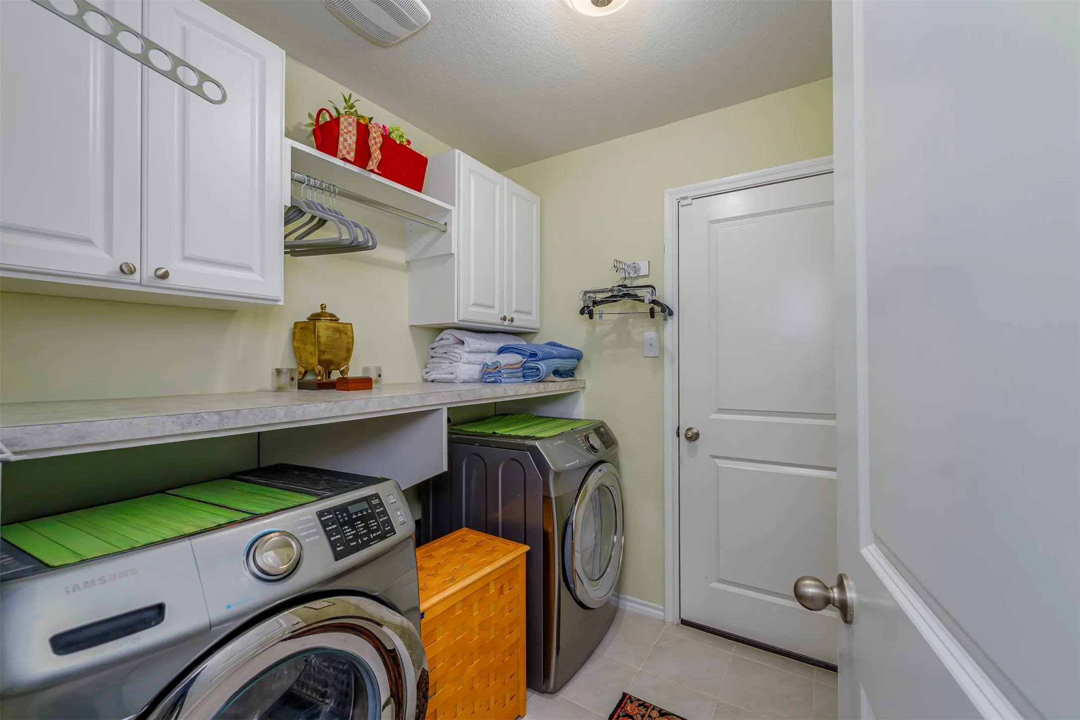 Laundry area featuring white cabinetry, a built-in hanging rod, and a spacious countertop