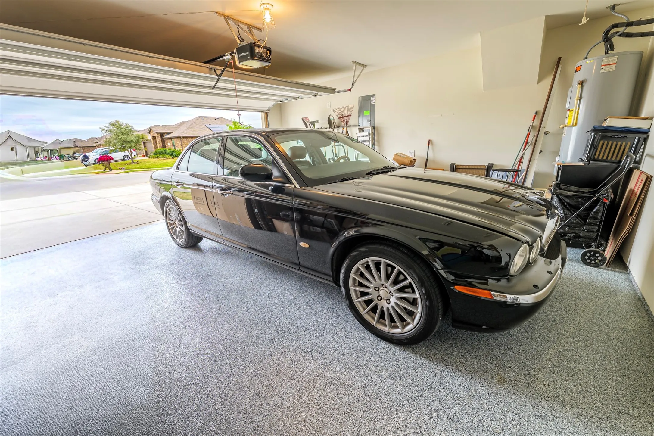 Attached garage with an overhead door, automatic opener, and a water heater