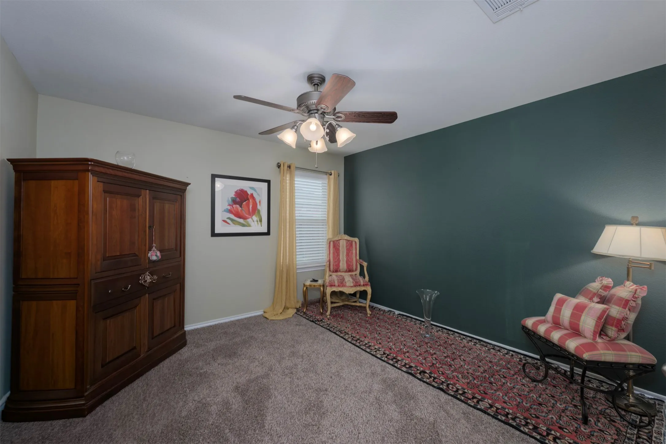 Carpeted flooring, ceiling fan with integrated lighting, window with blinds, and contrasting accent wall