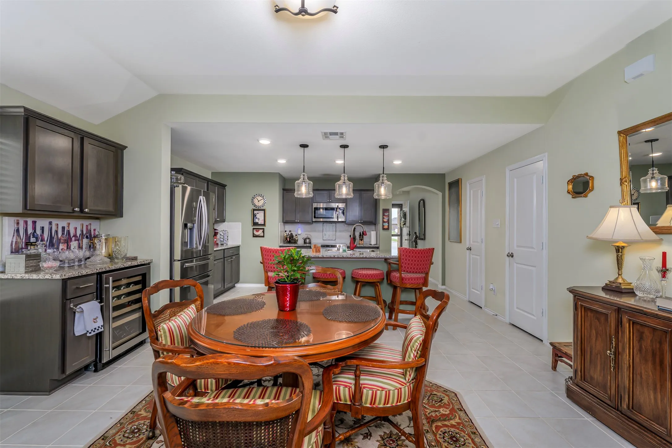 Recessed lighting, wood-finish cabinetry, stainless steel appliances, breakfast bar, and tile flooring