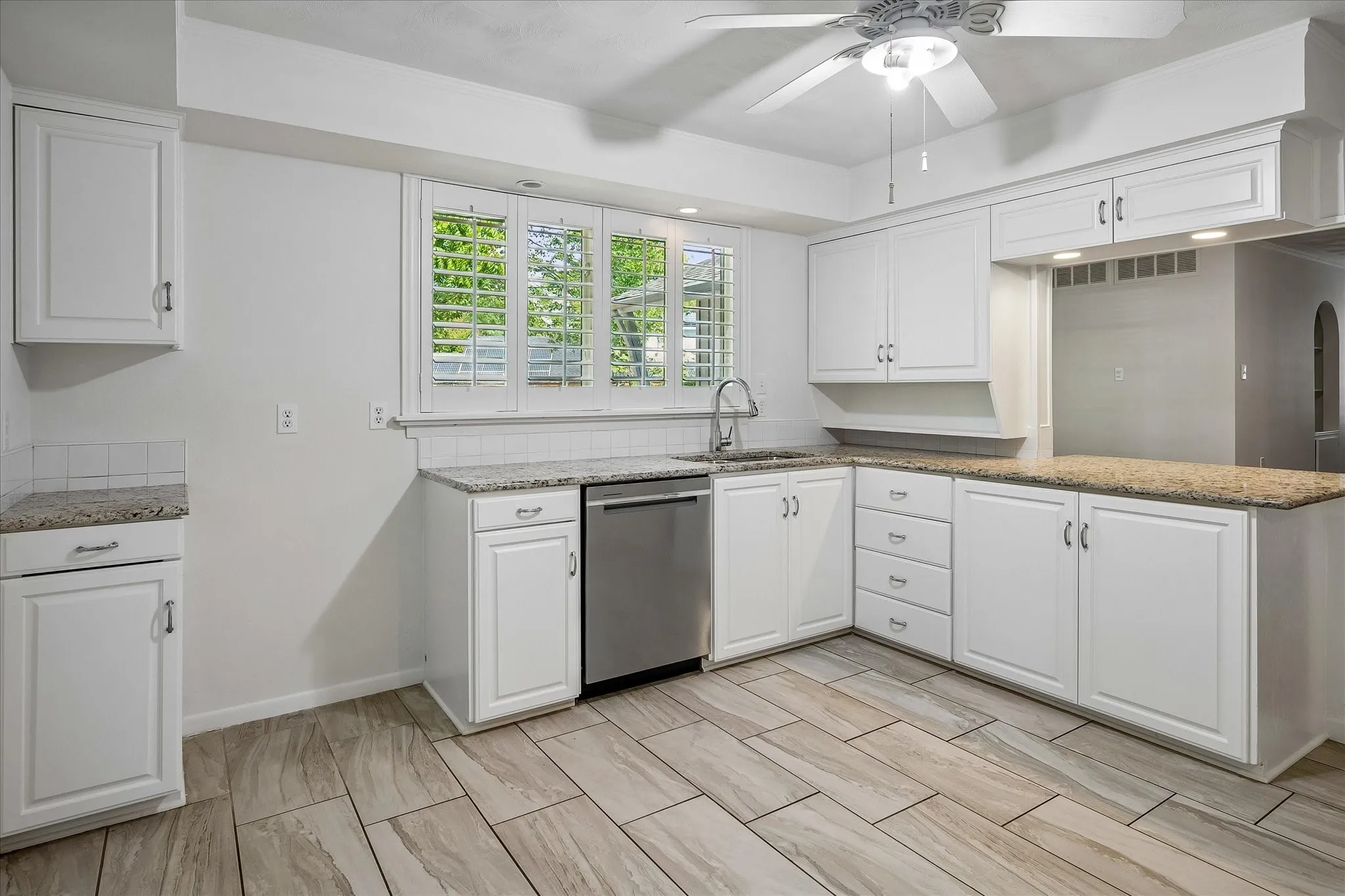 With room for a refrigerator the kitchen features a stainless steel dishwasher, and a ceiling fan with integrated lighting