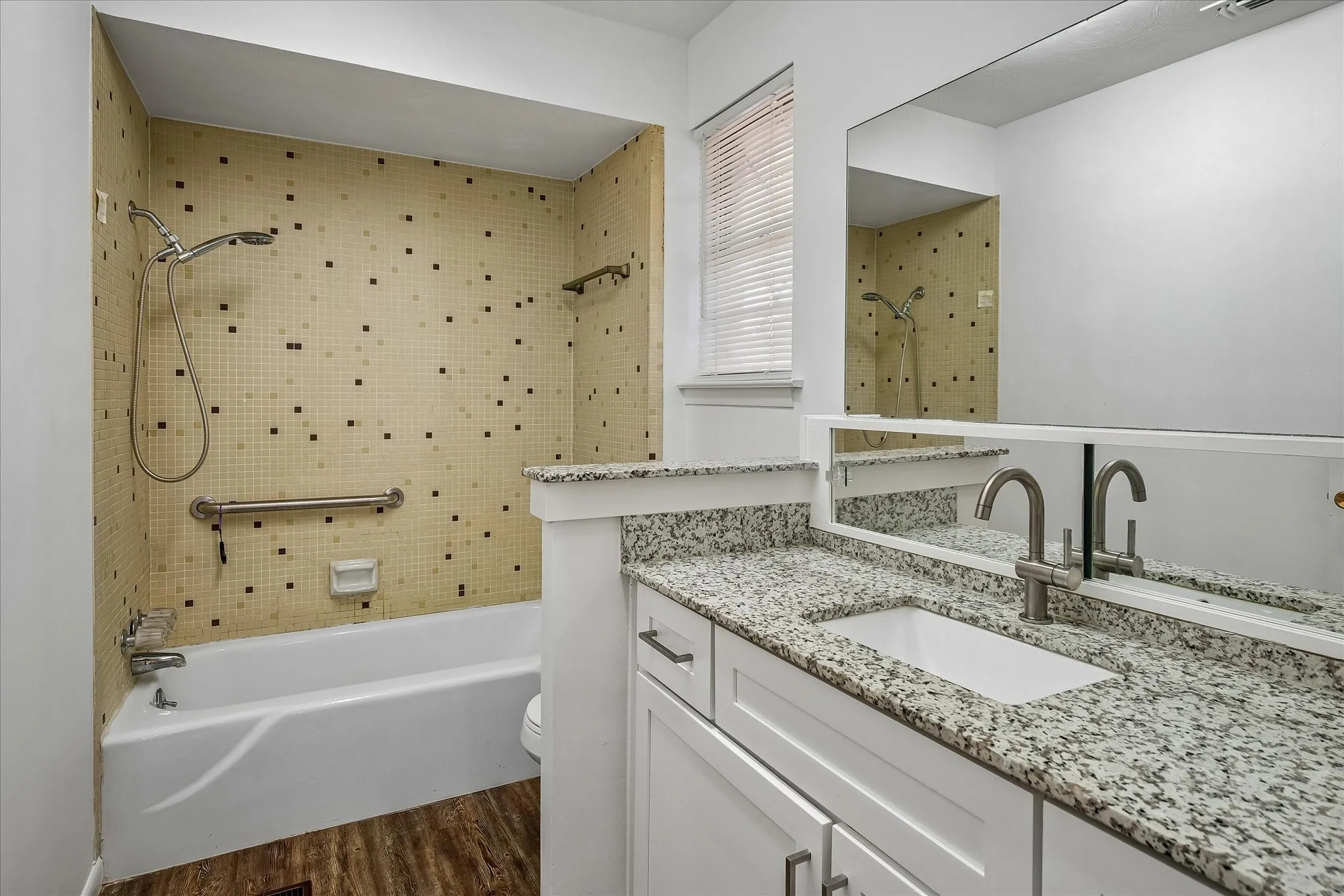 White vanity with granite-style countertop and integrated sink