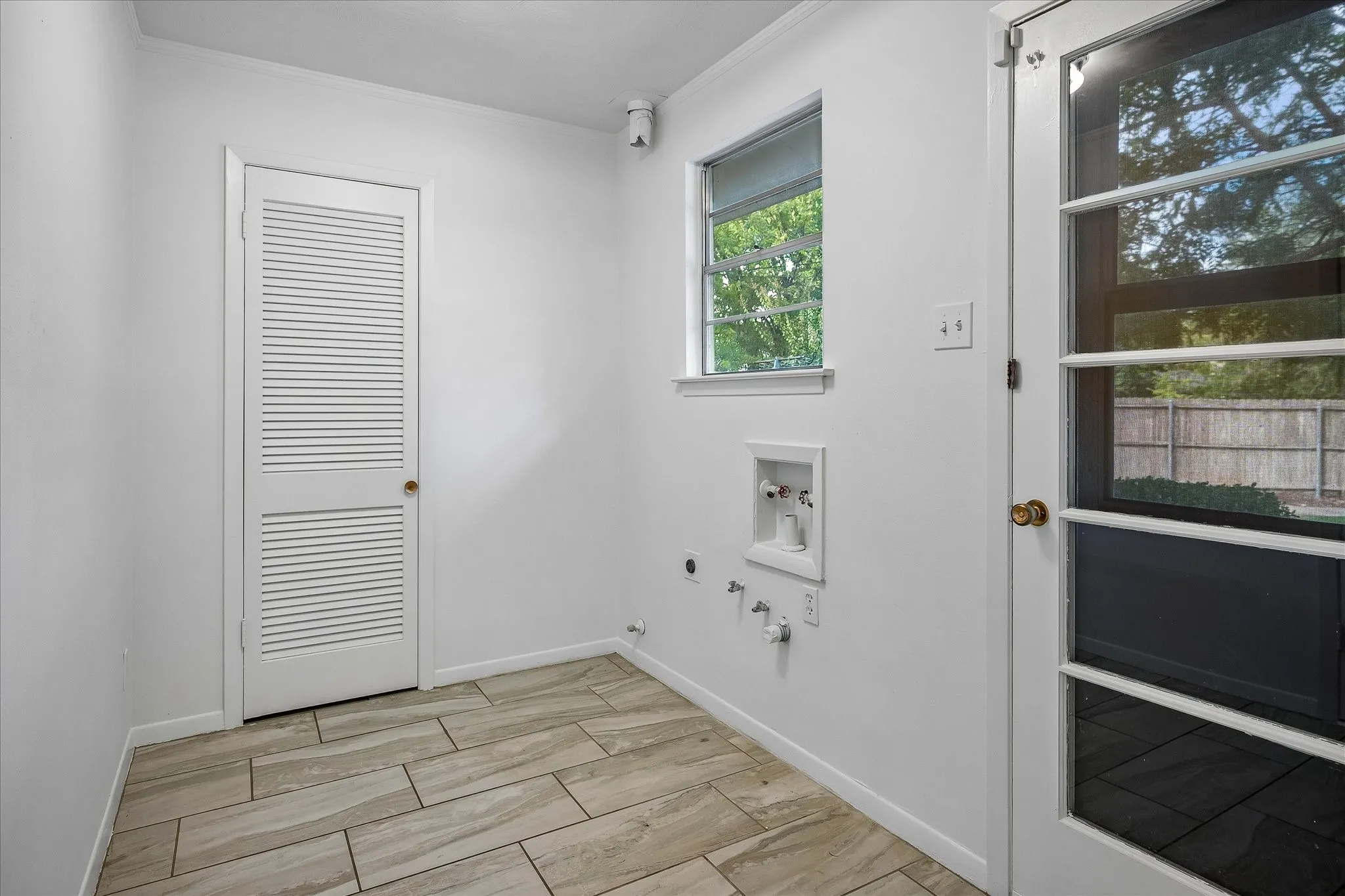 The light-filled laundry room features a LARGE pantry plus a glass-paneled exterior door to the patio