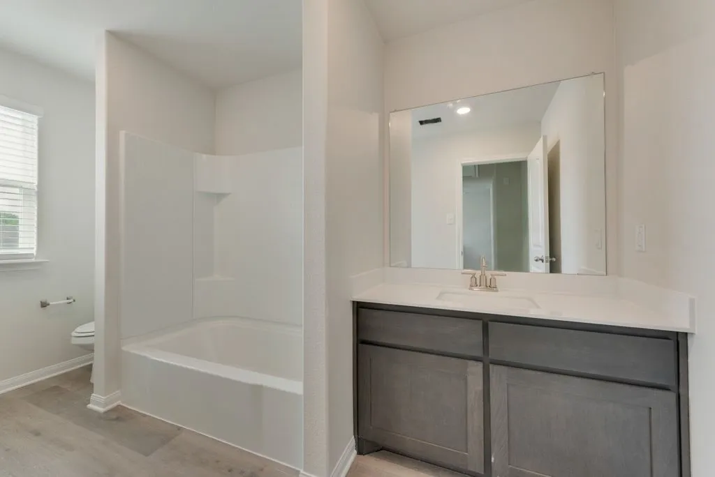 Full vanity with a single basin, light-toned countertop, and undermount sink