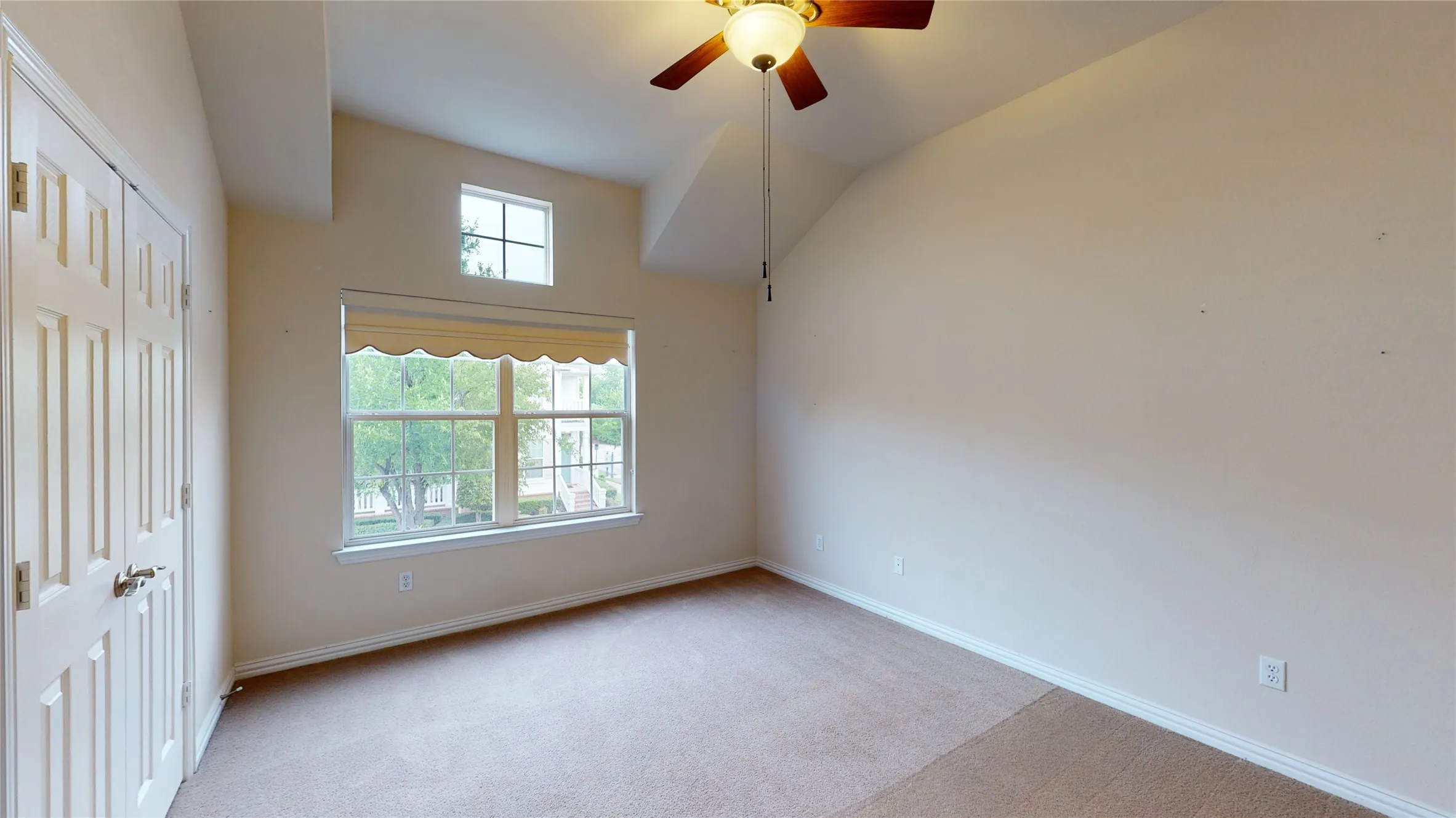 Second bedroom has tall ceilings and large closet with a ceiling fan