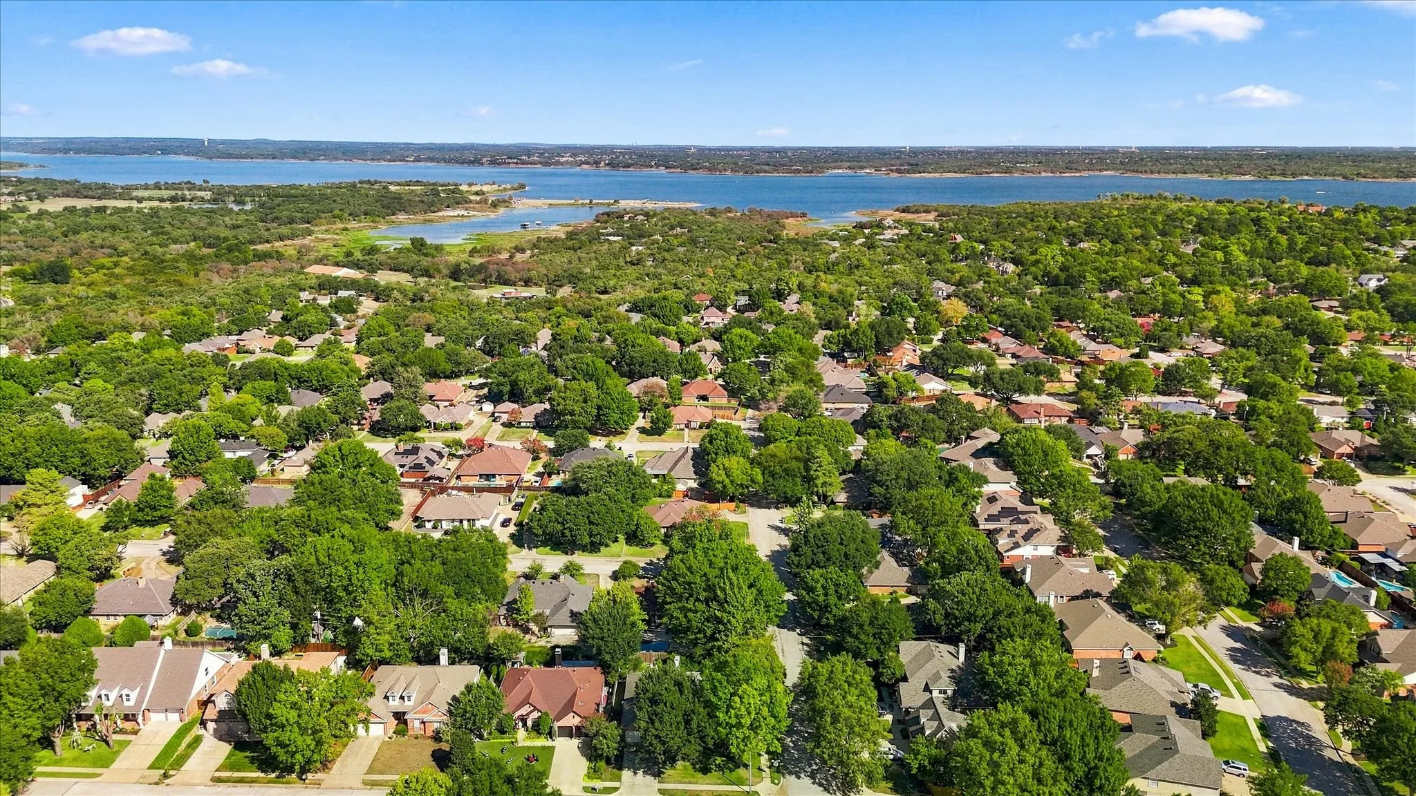 Neighborhood setting with mature trees and a distant body of water