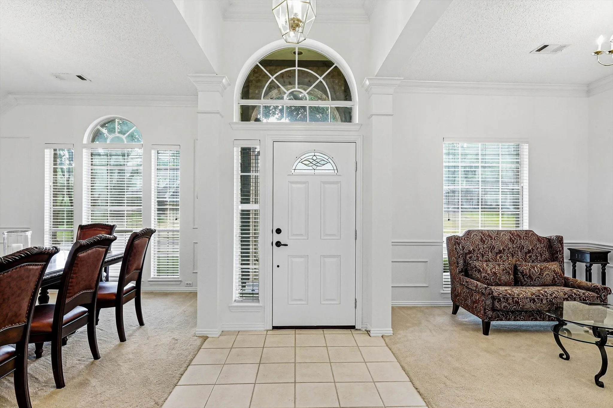 Grand entry with arched transom window, side lights, and tile flooring