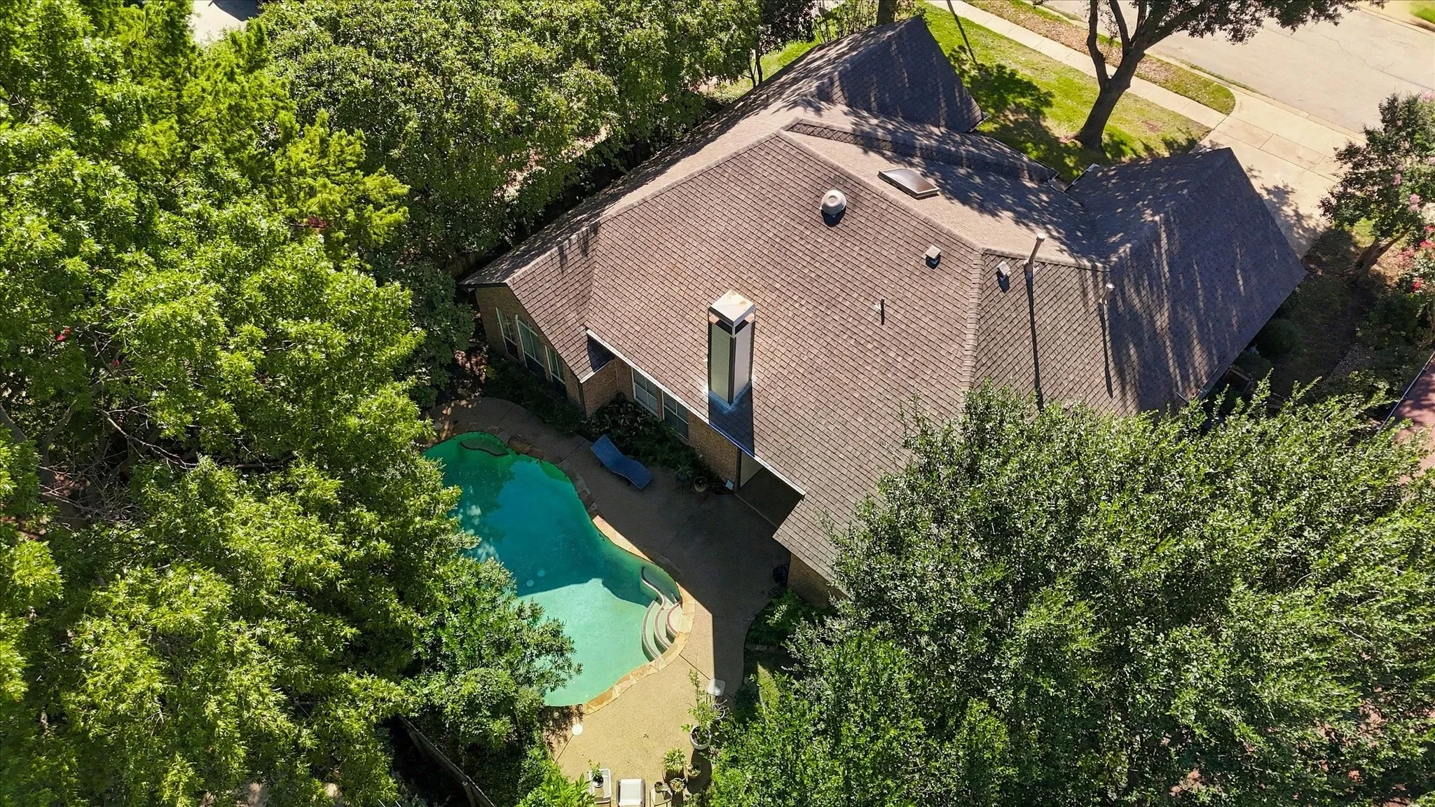 Asphalt shingle roofing over a single-story structure with a prominent chimney