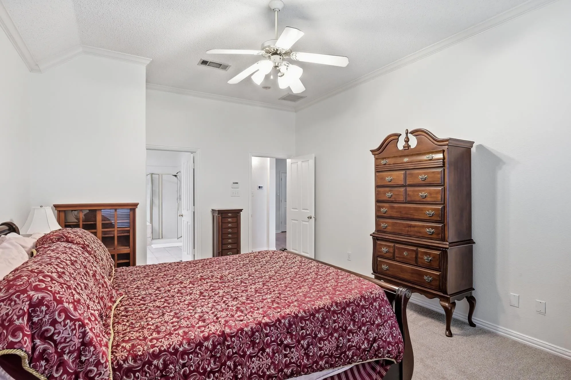 White walls with crown molding, ceiling fan, and light gray carpeting