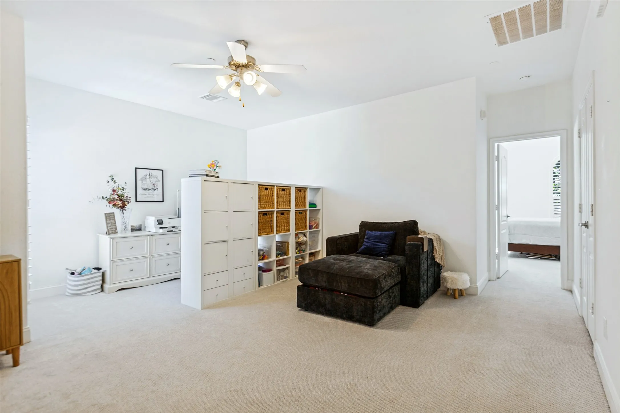 Expansive carpeted bonus room with future 3rd bedroom potential featuring a ceiling fan with integrated lighting, recessed lighting, and a doorway leading to an full sized laundry room.