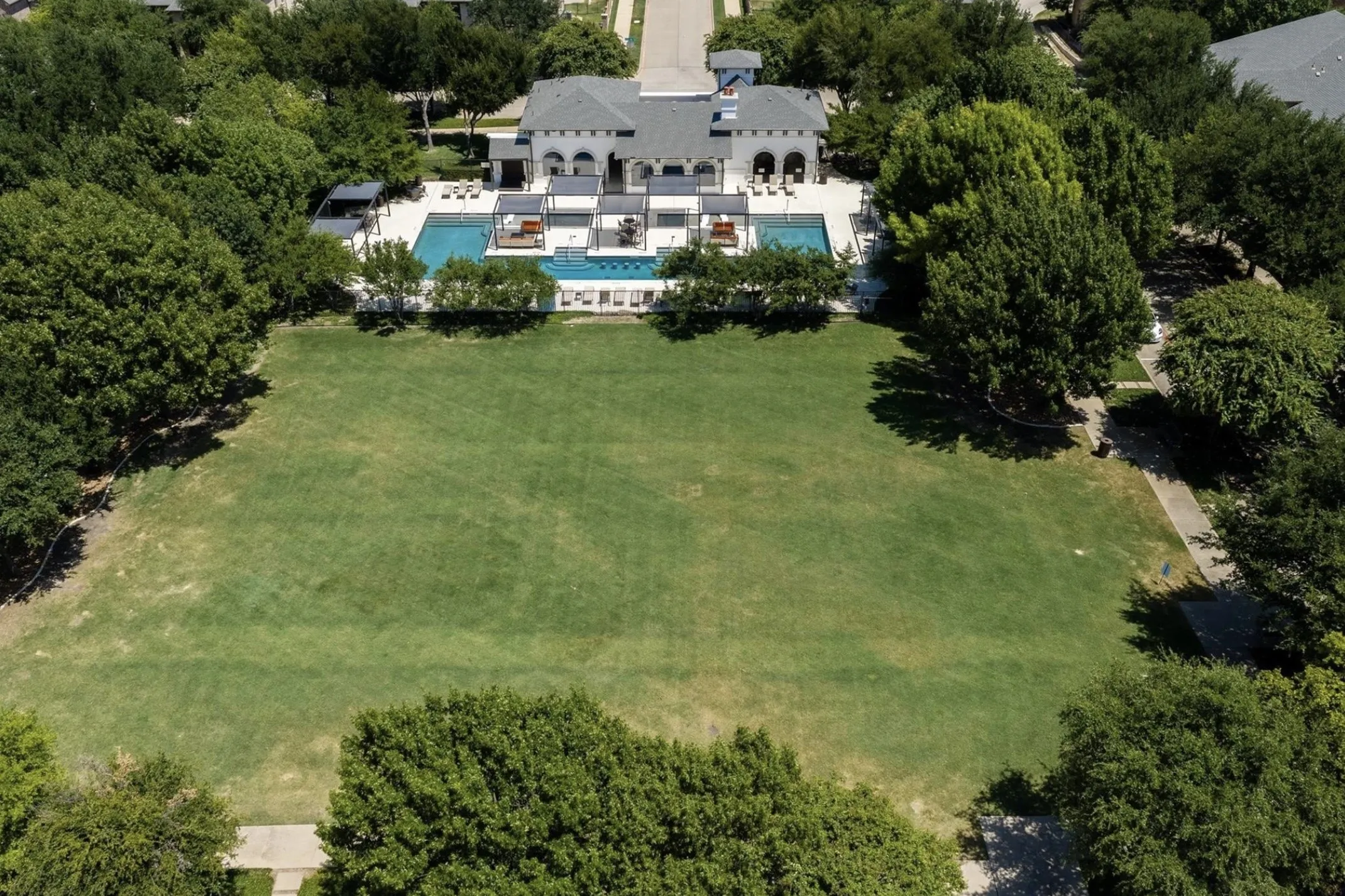 Expansive green space featuring a large lawn and mature trees