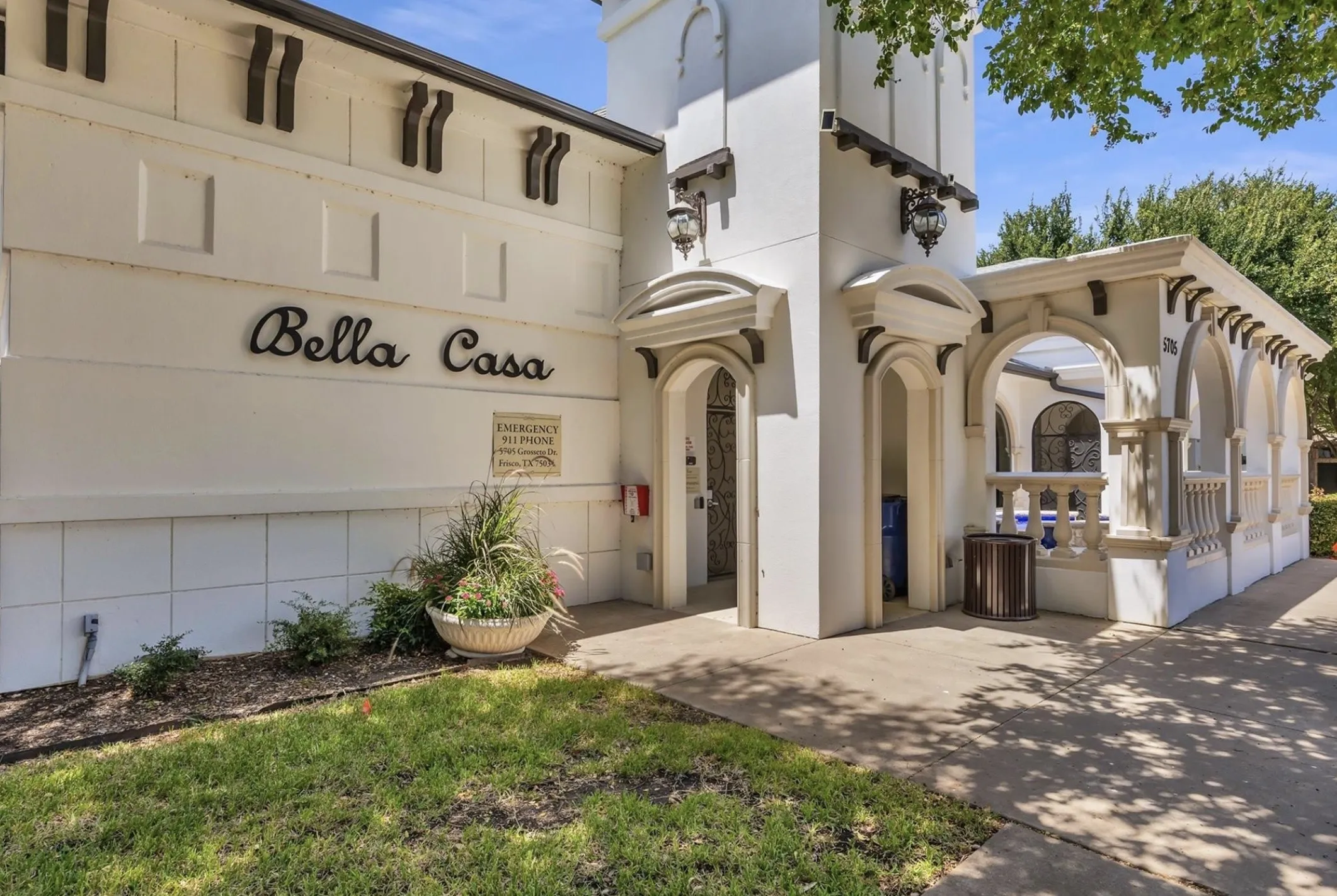 Spanish Colonial style architecture with arched doorways, decorative corbels, and exterior wall sconces