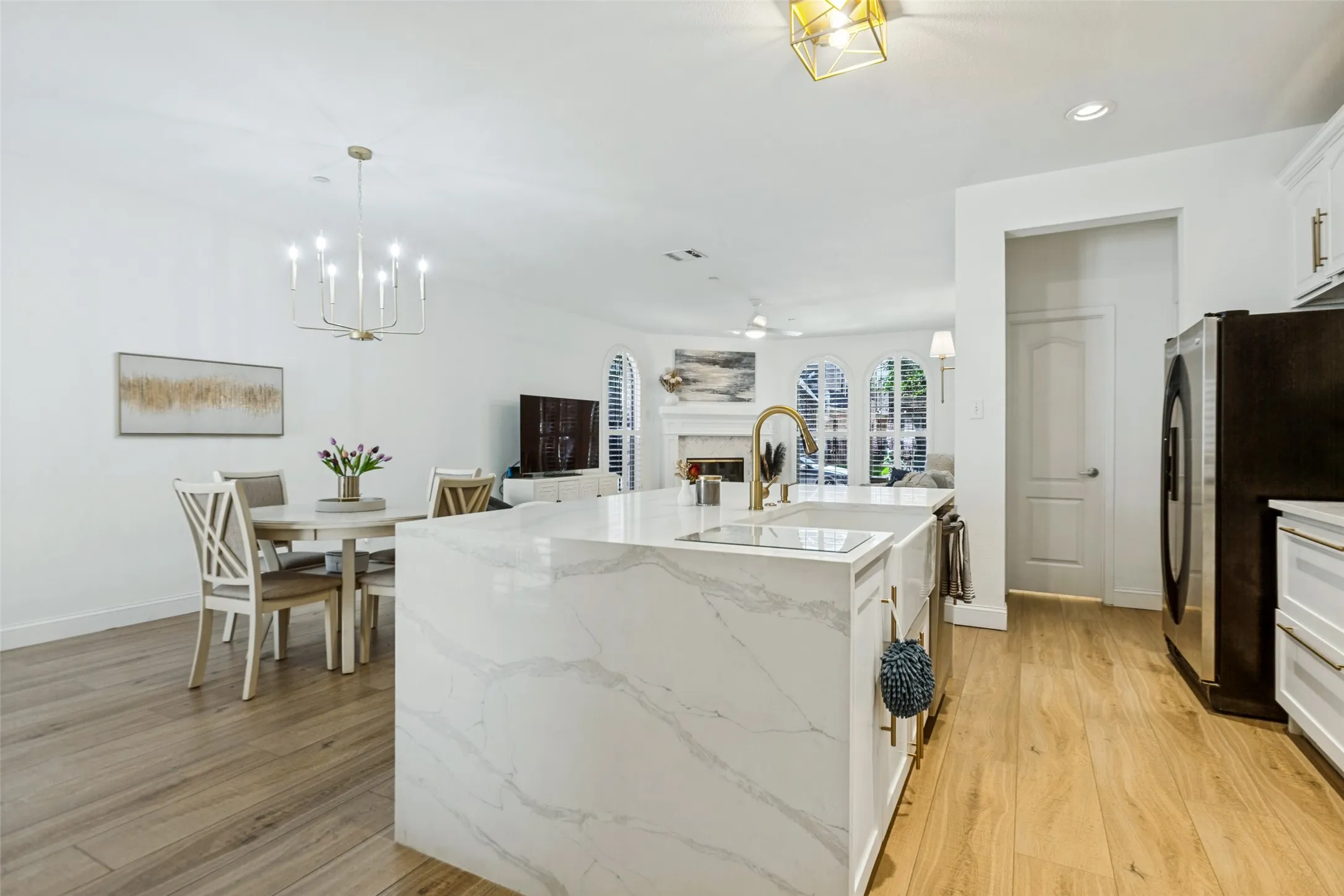 Quartz waterfall island with farm sink and gooseneck faucet