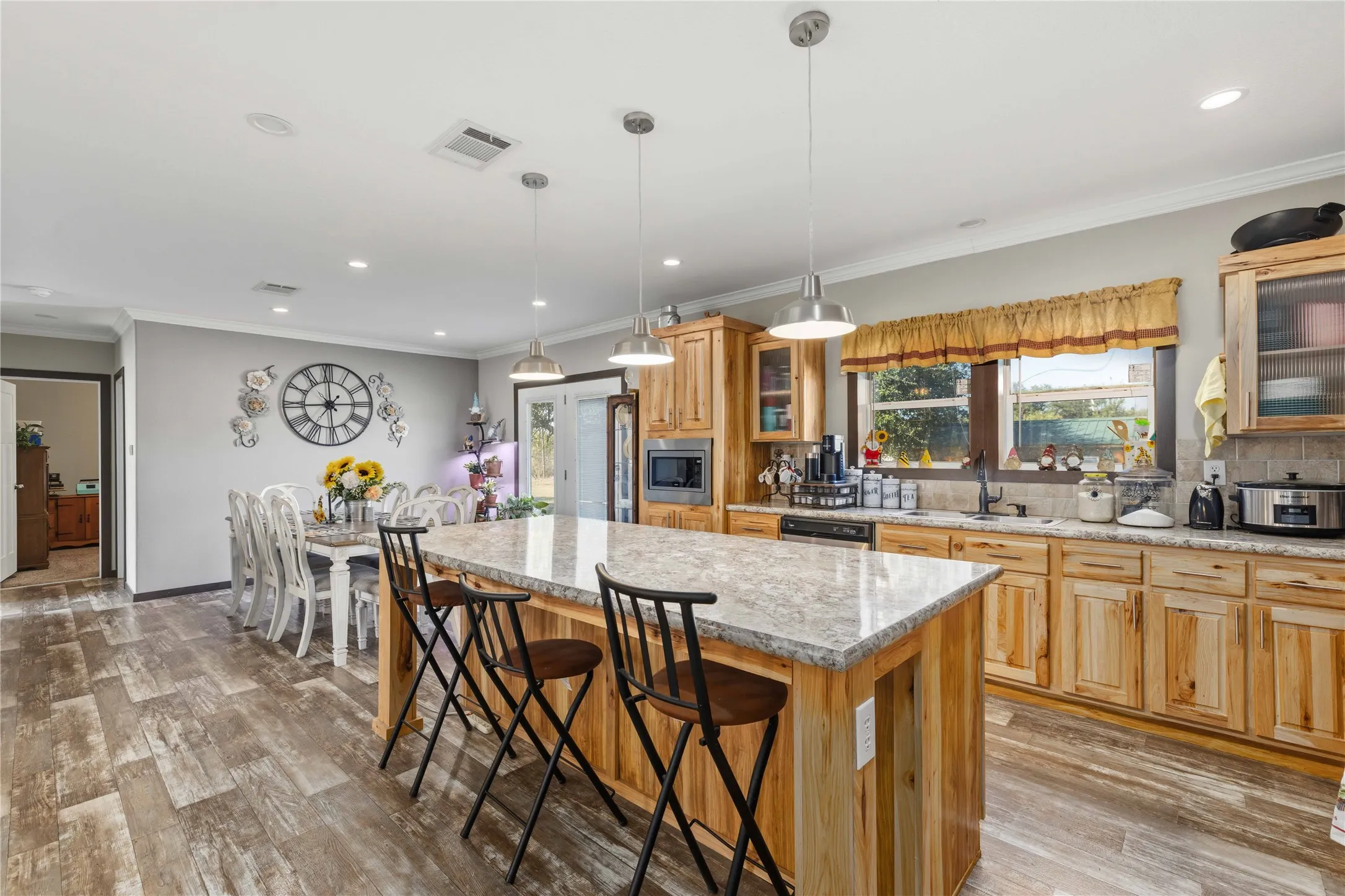 Wood-finish flooring, recessed lighting, and a kitchen island with seating