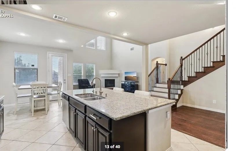Kitchen island with integrated sink, stainless steel dishwasher, and granite-style countertop