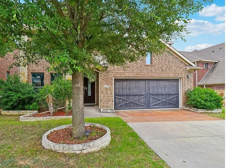 Brick and stone facade with a decorative wood-finish garage door