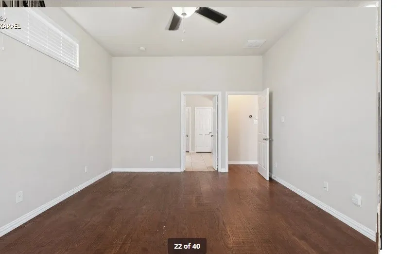 Wood-finish flooring, light-toned walls, and a ceiling fan with integrated lighting