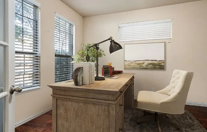 Hardwood flooring, multiple windows with blinds, light-toned wall paint, and a white paneled door