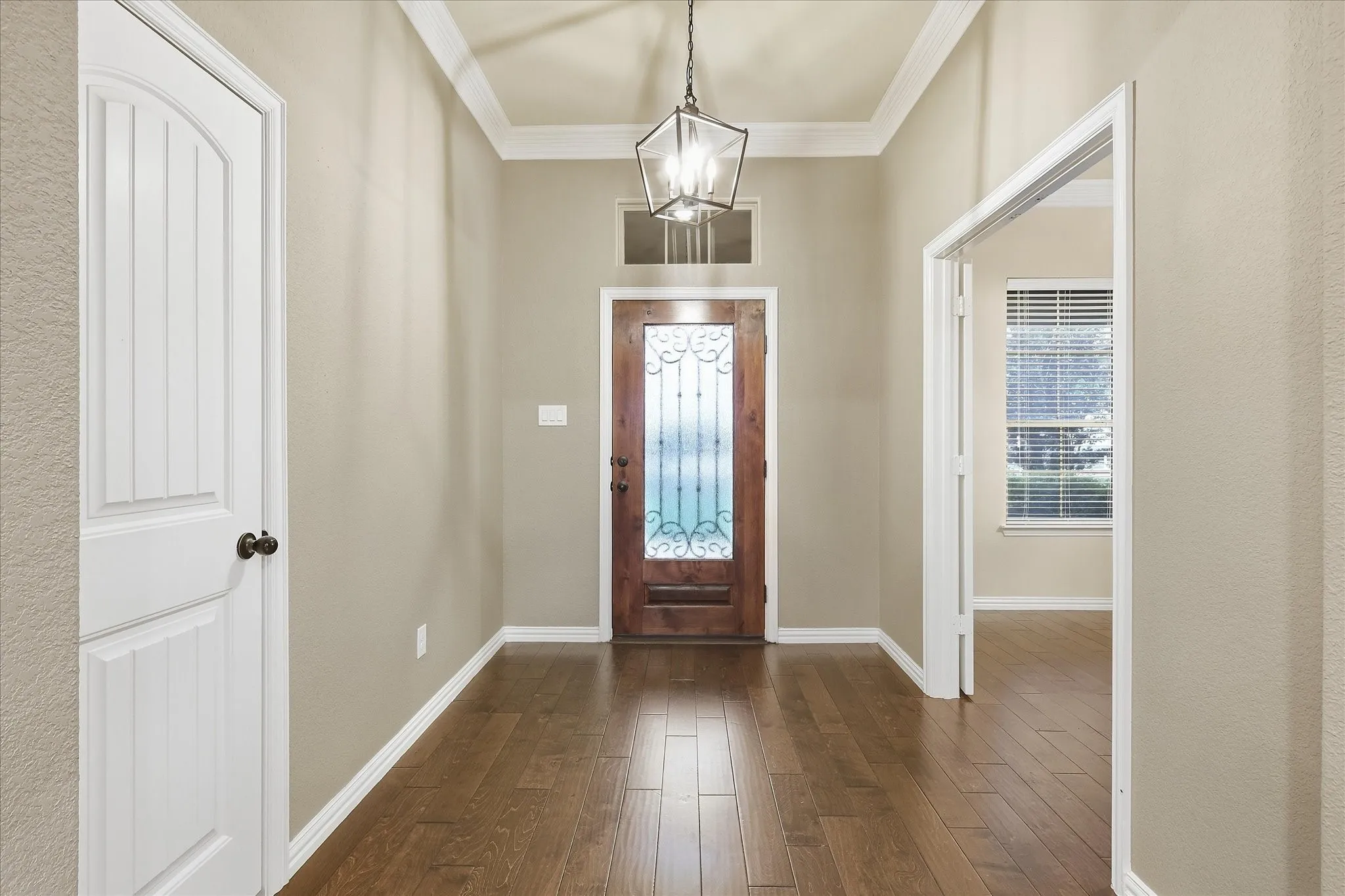 Entryway featuring wood-finish flooring, a decorative glass-paneled door, and a multi-bulb lantern pendant light