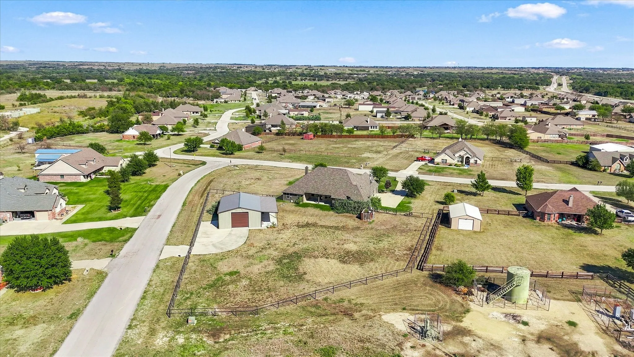 Expansive property featuring a single-story residence, detached garage, and additional outbuilding