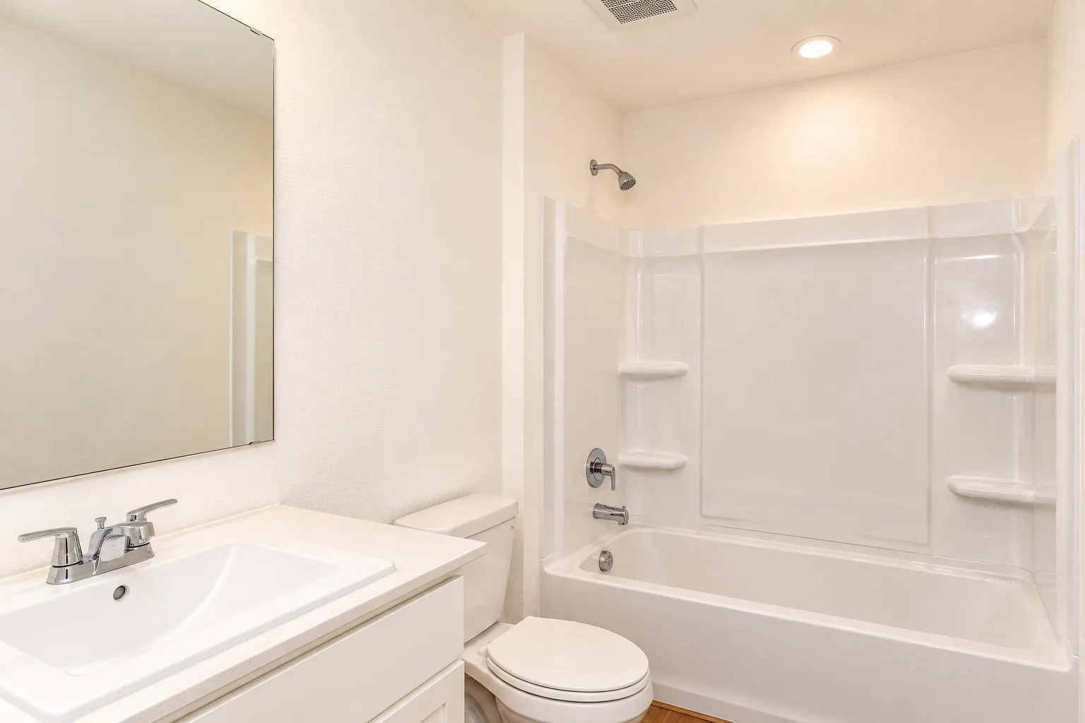 White vanity with integrated sink, chrome faucet, and rectangular mirror