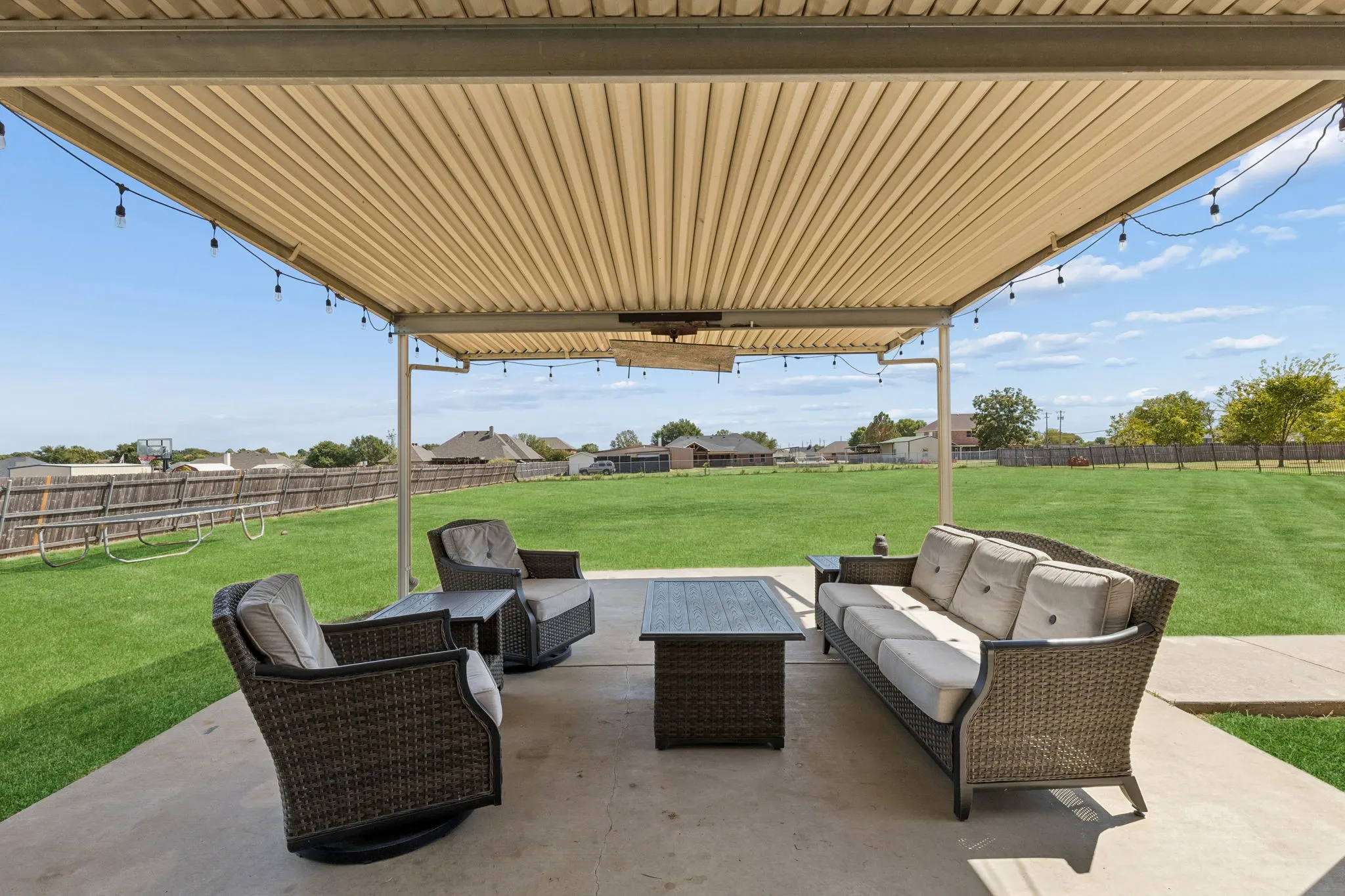Expansive covered patio featuring a corrugated metal roof and concrete flooring