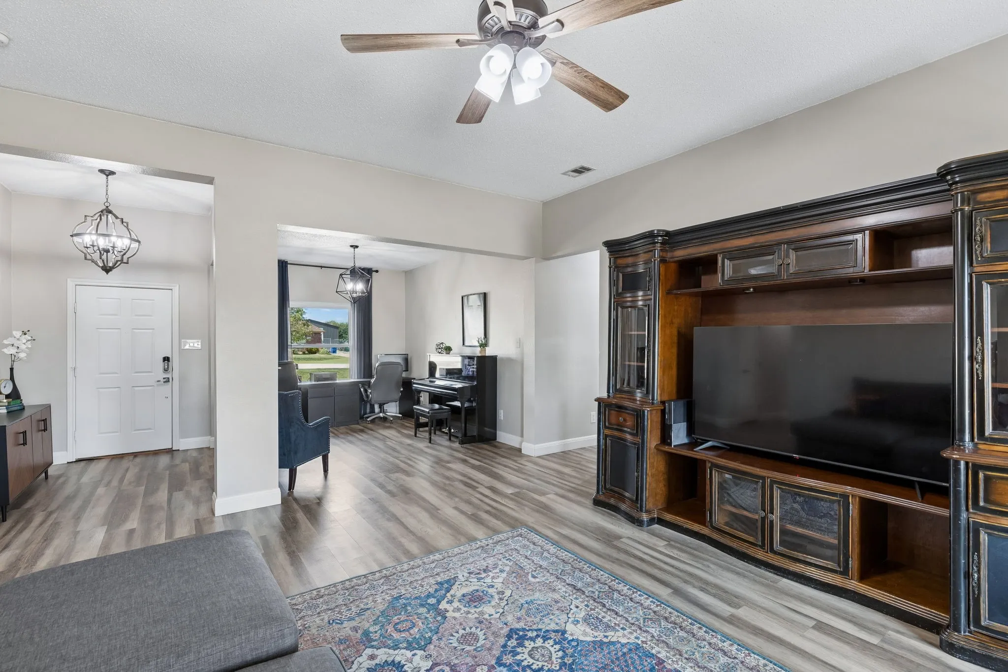 Wood-finish flooring throughout, complemented by a decorative ceiling fan