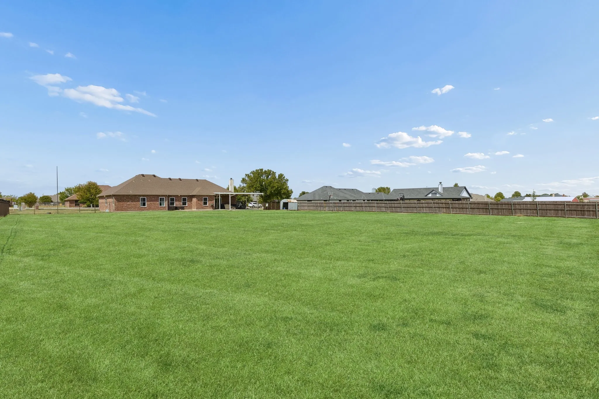 Expansive lawn with a wood fence perimeter