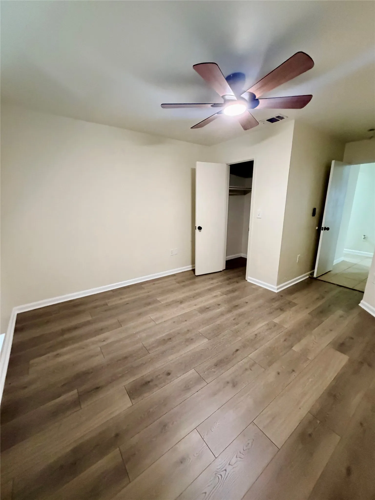 Wood-finish flooring with a ceiling fan featuring integrated​​‌​​​​‌​​‌‌​‌‌​​​‌‌​‌​‌​‌​​​‌​​ lighting