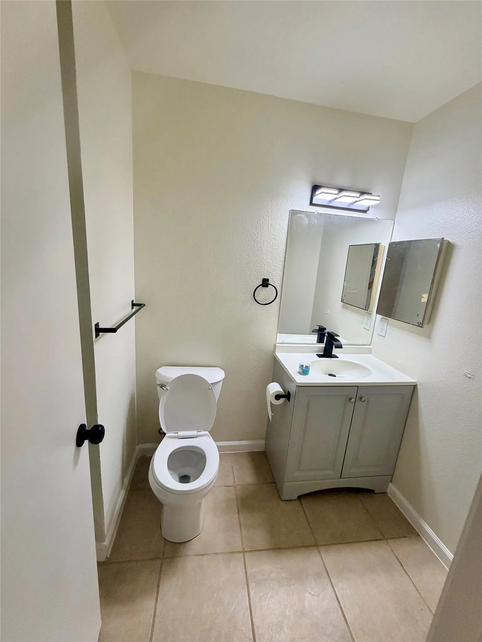 Vanity with cabinet storage, integrated sink, and black-finish faucet