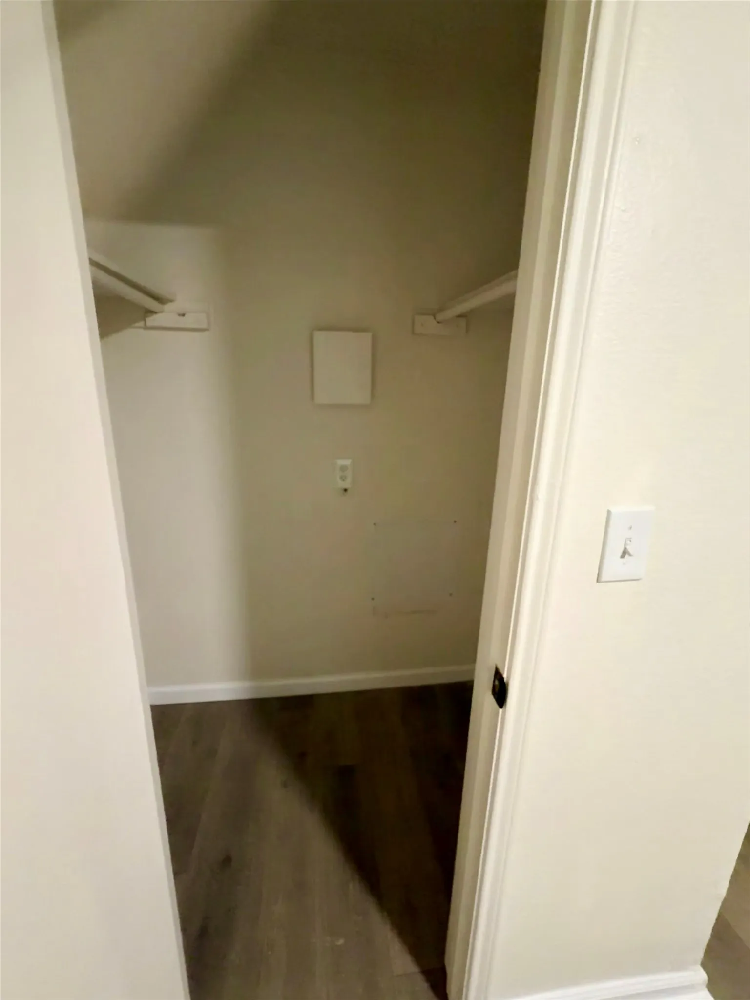 Built-in shelving brackets and wood-finish flooring in a recessed storage area