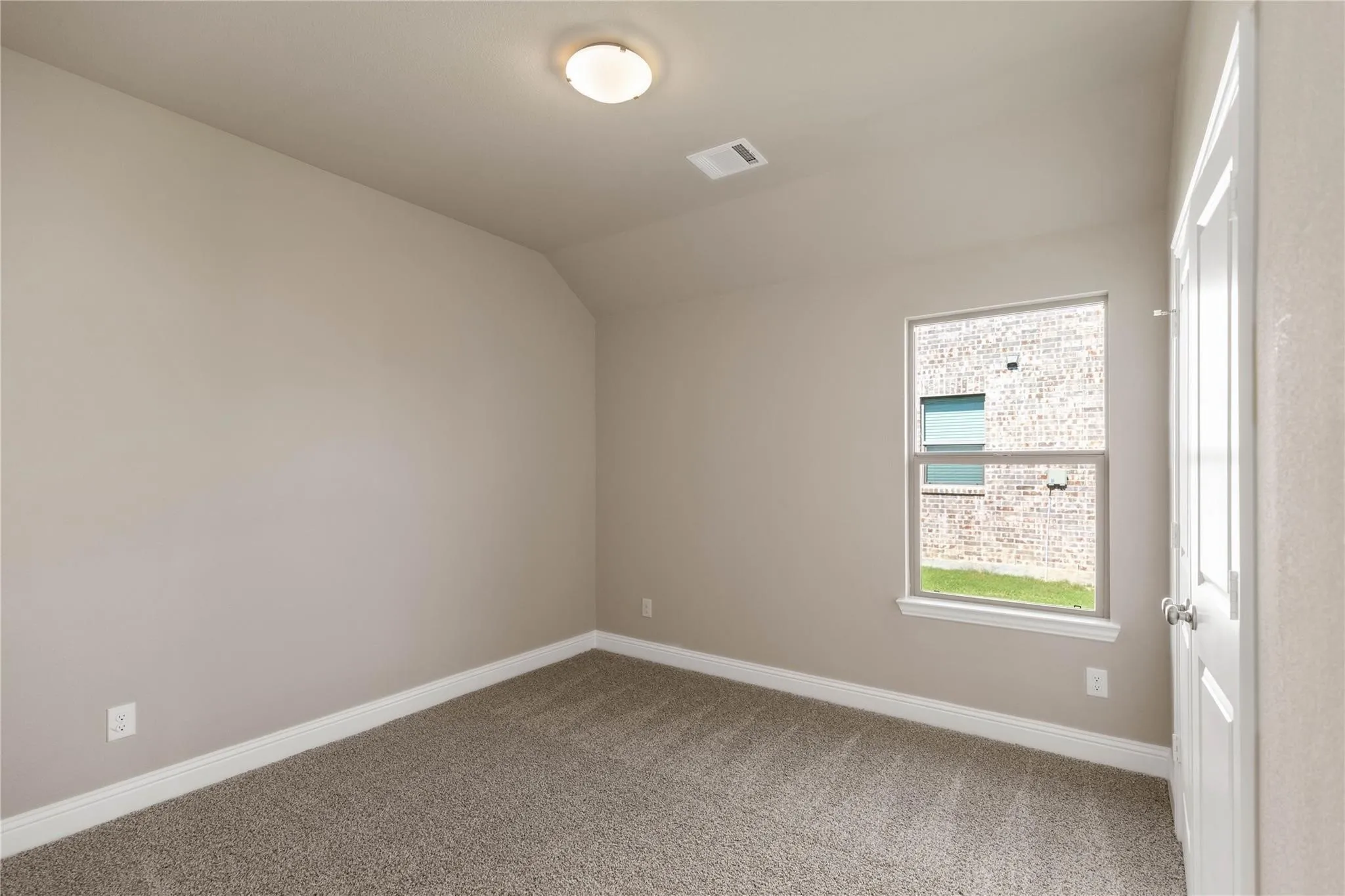 Neutral tone painted walls, a single window, and a flush mount ceiling light fixture