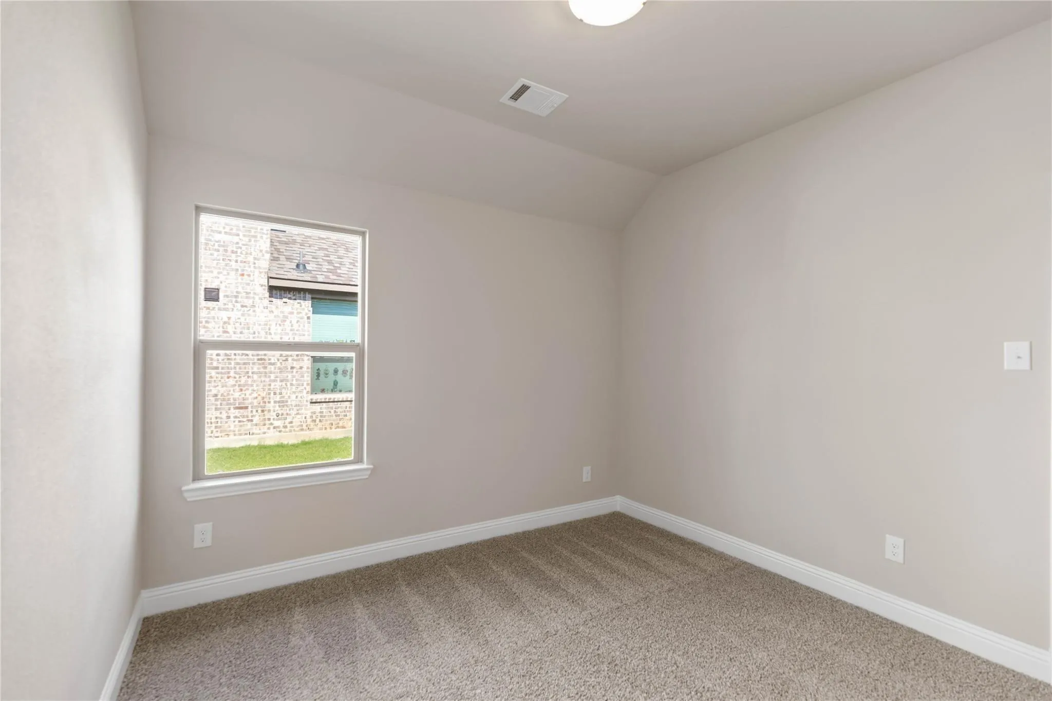 Carpeted flooring, vaulted ceiling, single window, flush mount ceiling light fixture, neutral wall color