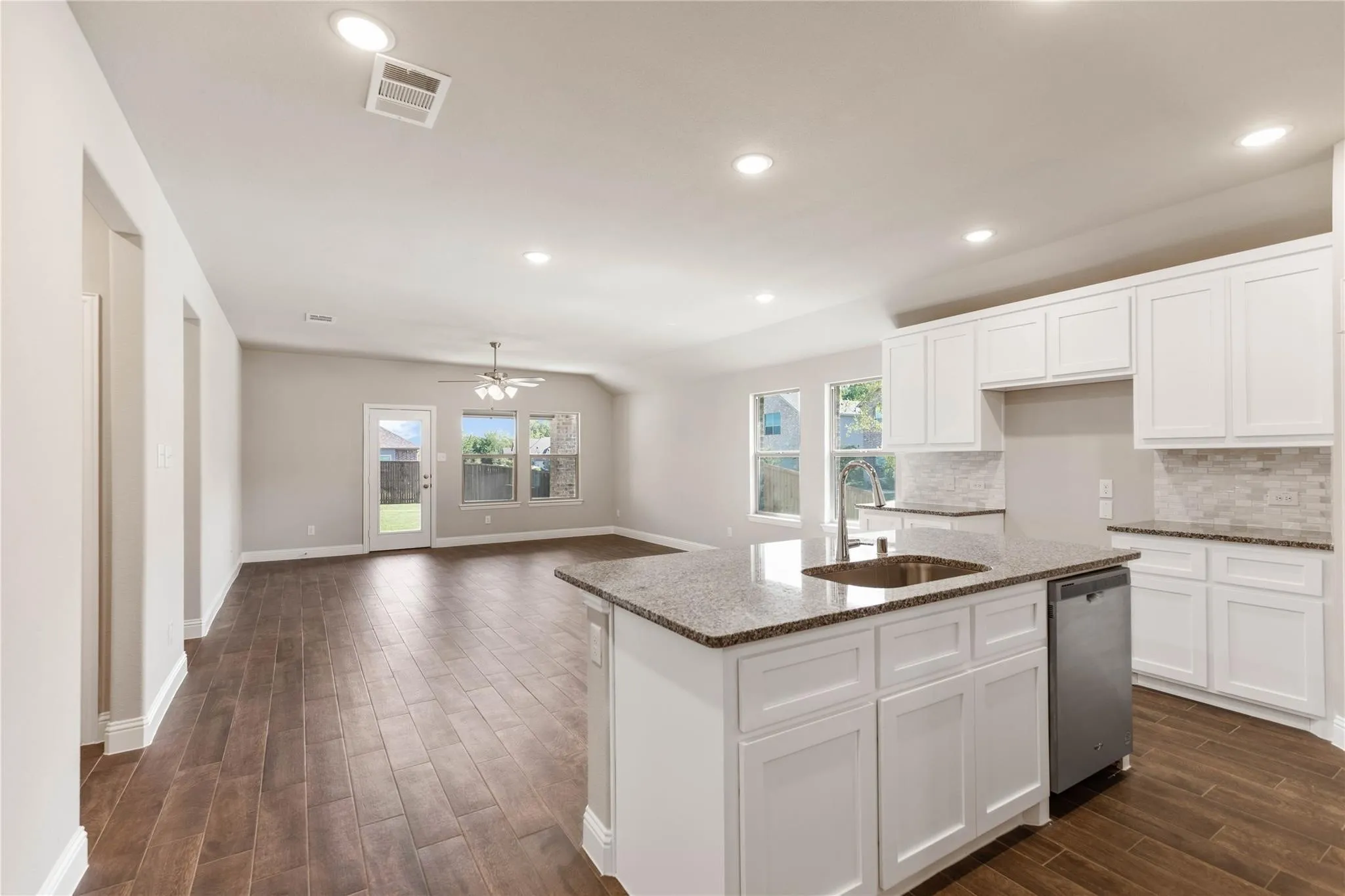 Open-concept living space featuring wood-finish flooring, recessed lighting, and a ceiling fan