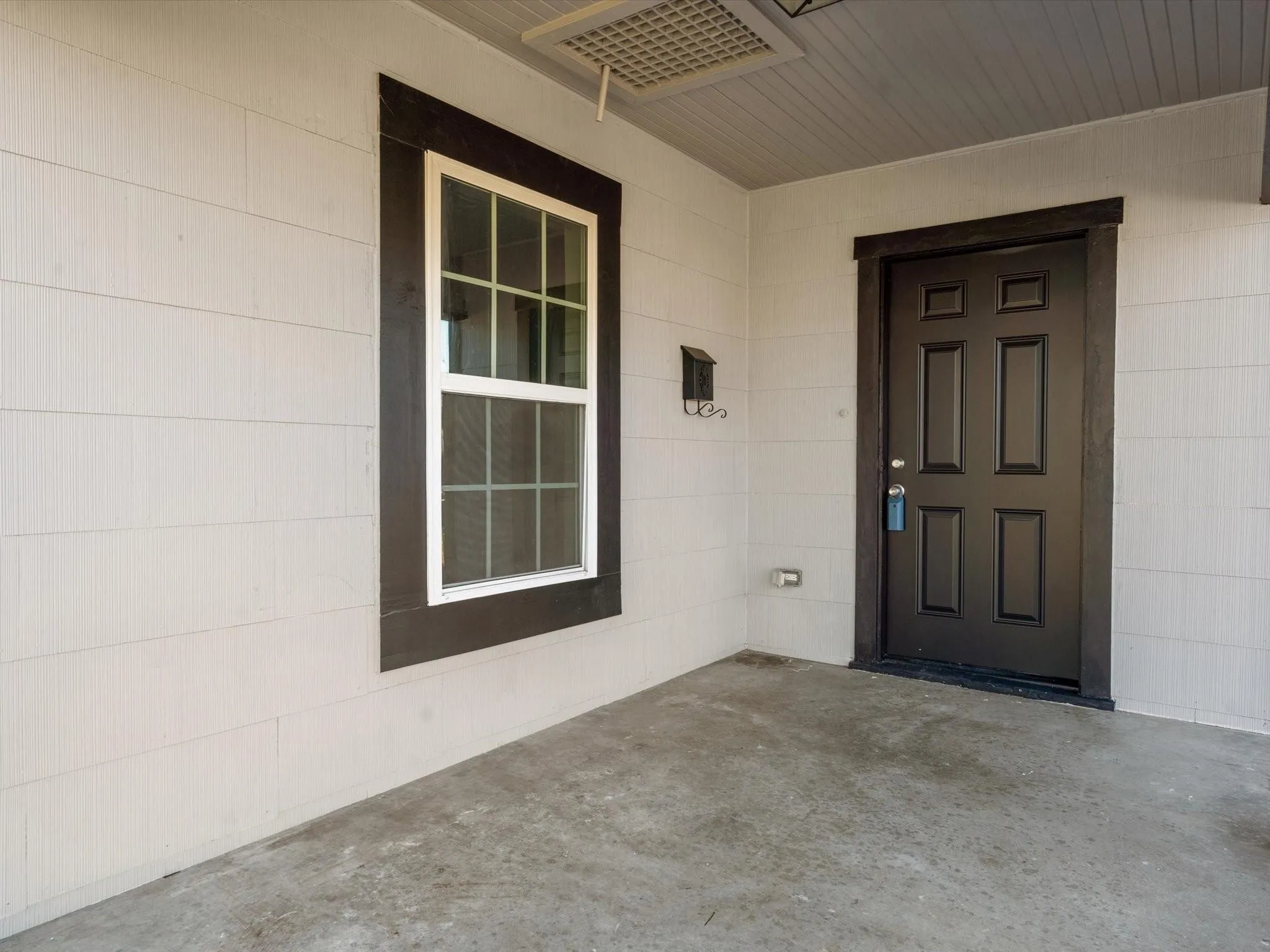 Entryway featuring a paneled door, exterior wall siding, and concrete flooring