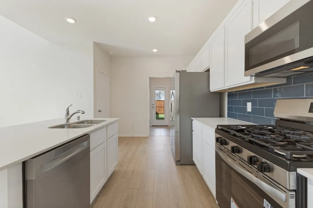 Fully equipped kitchen with stainless steel appliances including fridge
