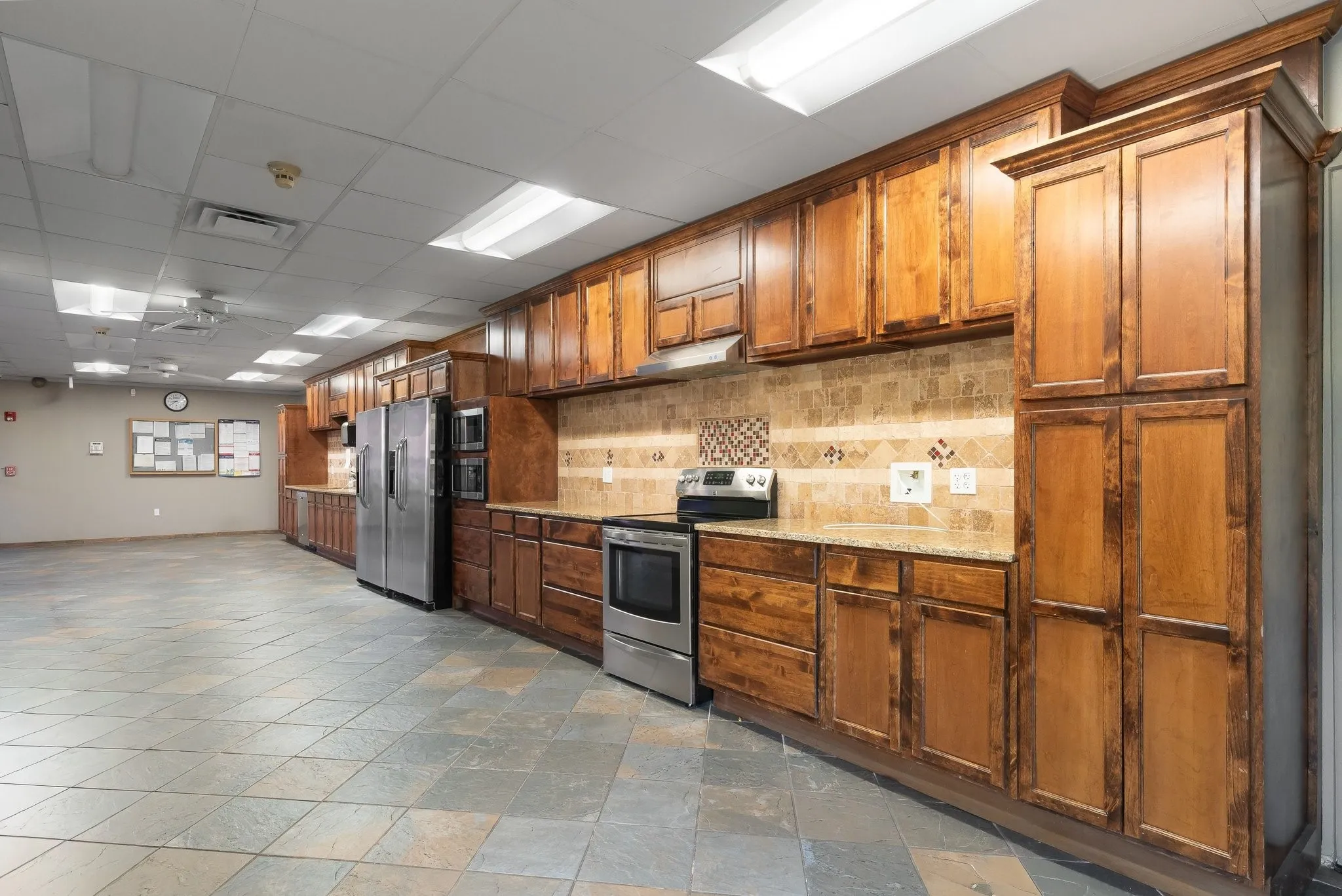 Extensive wood-finish cabinetry, granite-style countertops, and a full tile backsplash