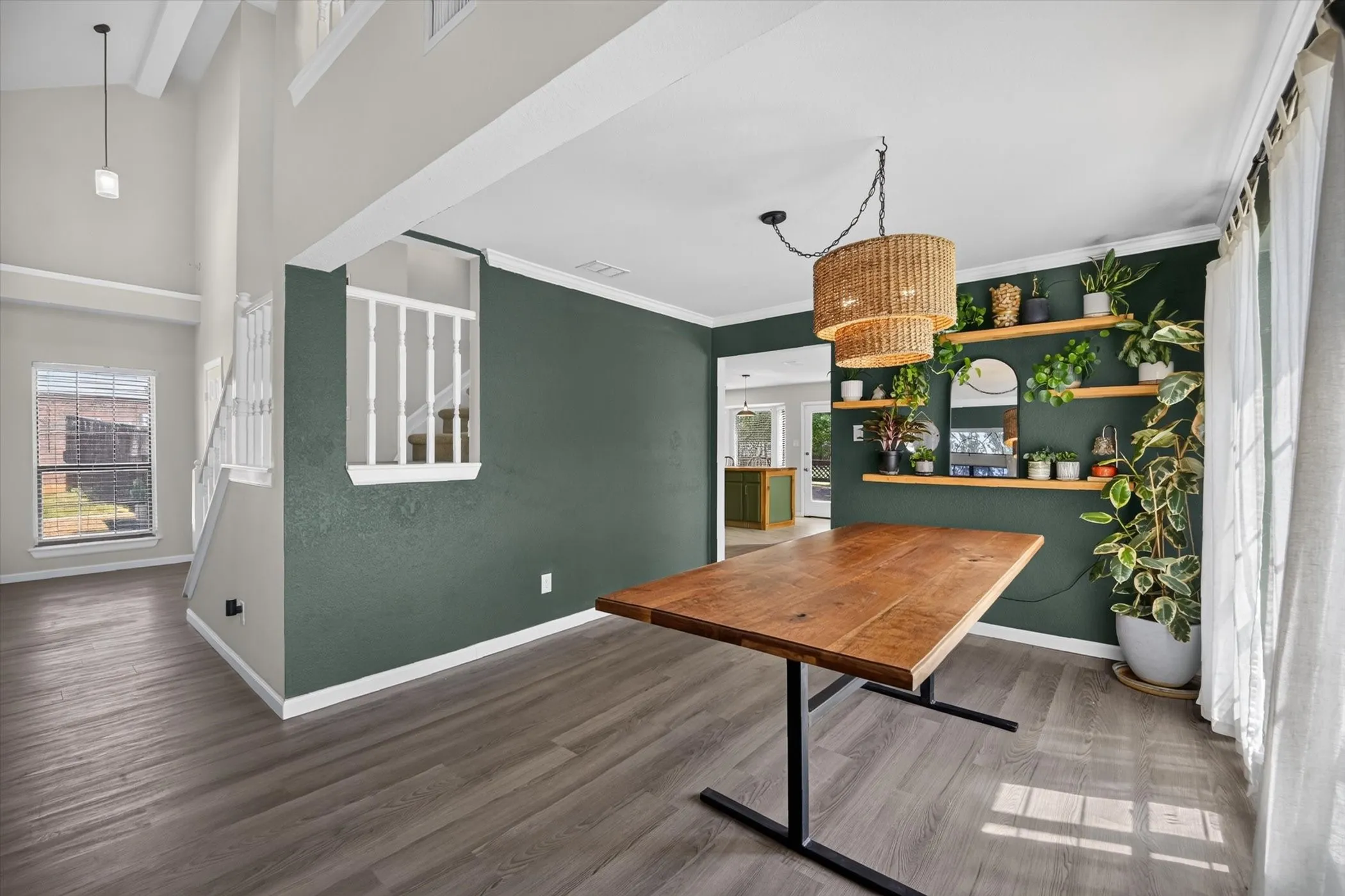 Wood-finish flooring throughout, complemented by a two-story ceiling in the adjacent area