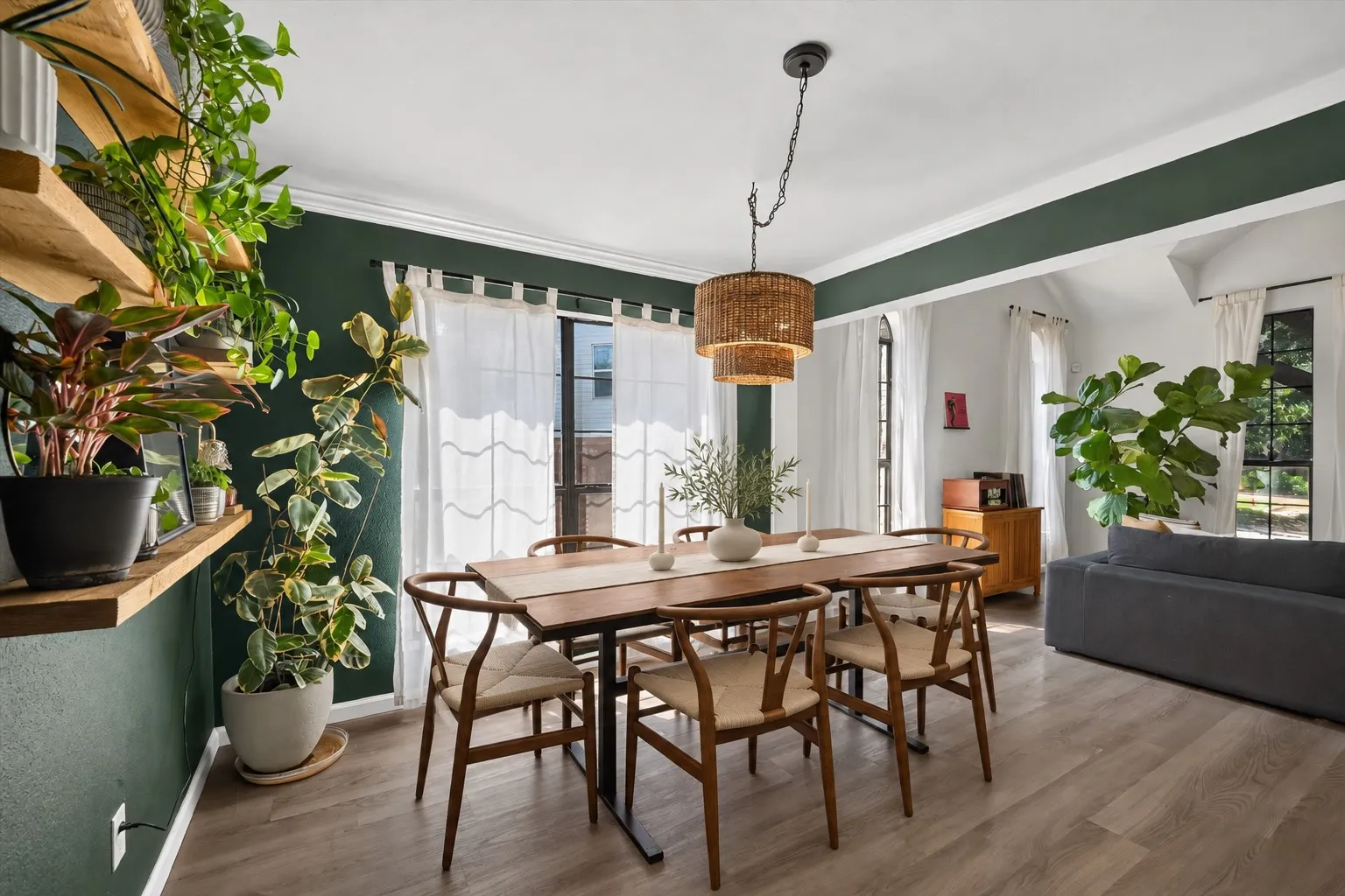 *virtually staged chairs and tablescape* Wood-finish flooring throughout, featuring a layered woven pendant light fixture