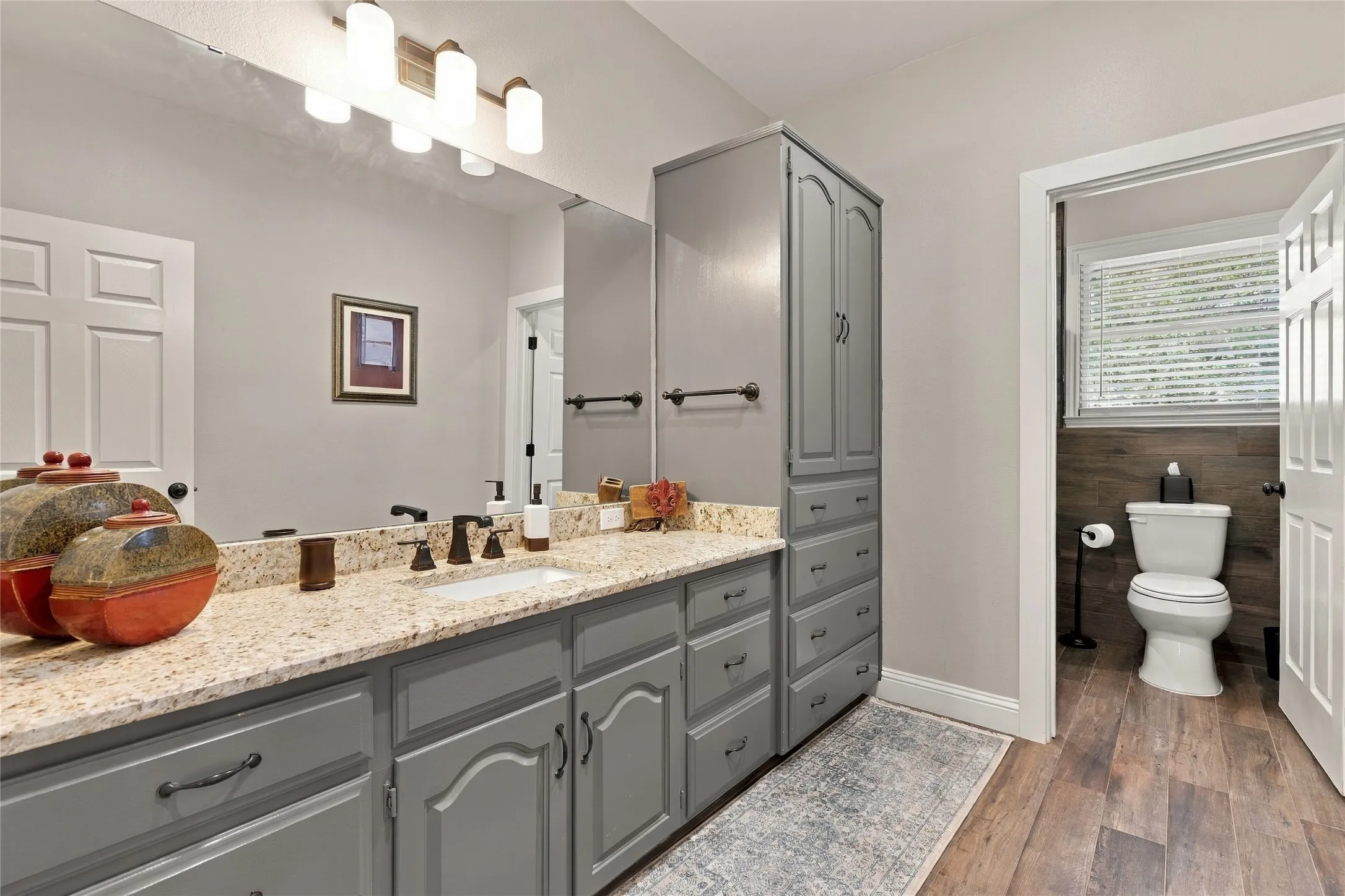 Dual vanity with granite countertop, integrated sink, and dark bronze fixtures