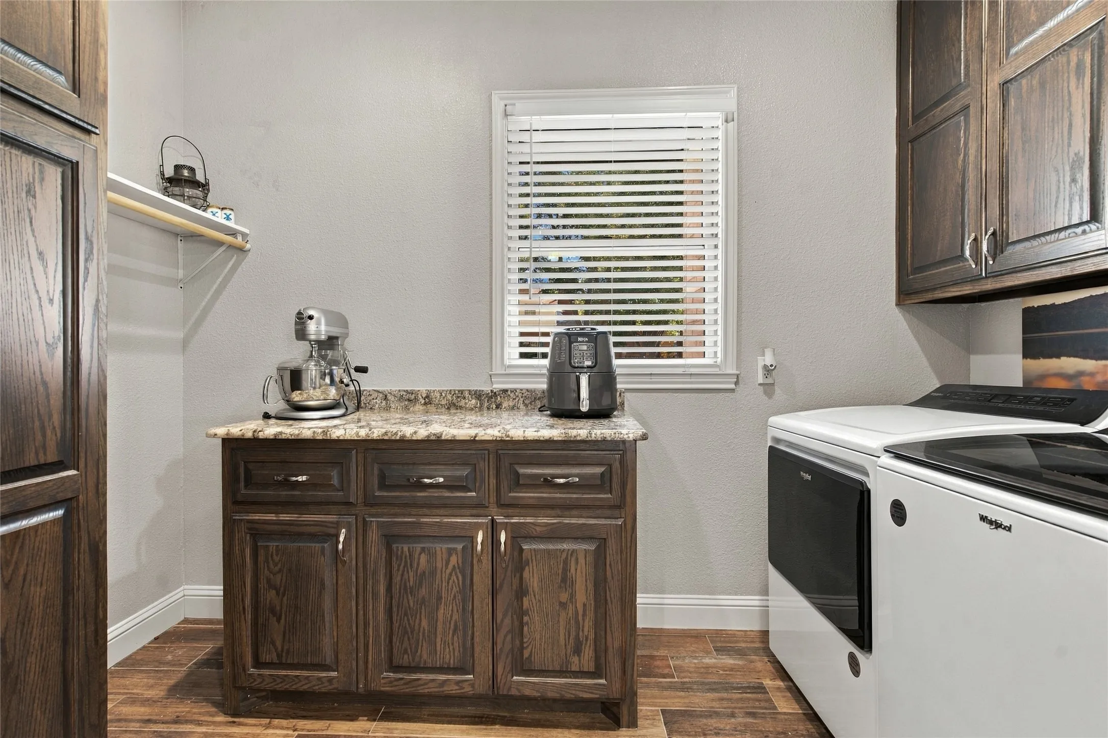 Wood-finish flooring with a built-in lower cabinet featuring a stone countertop