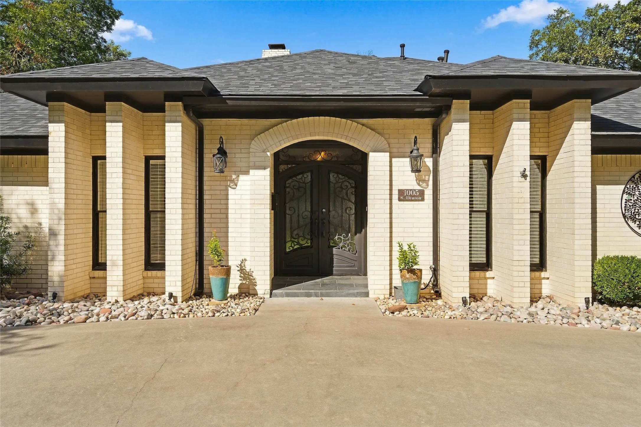 Elegant cream brick facade with bold architectural columns framing an arched entry