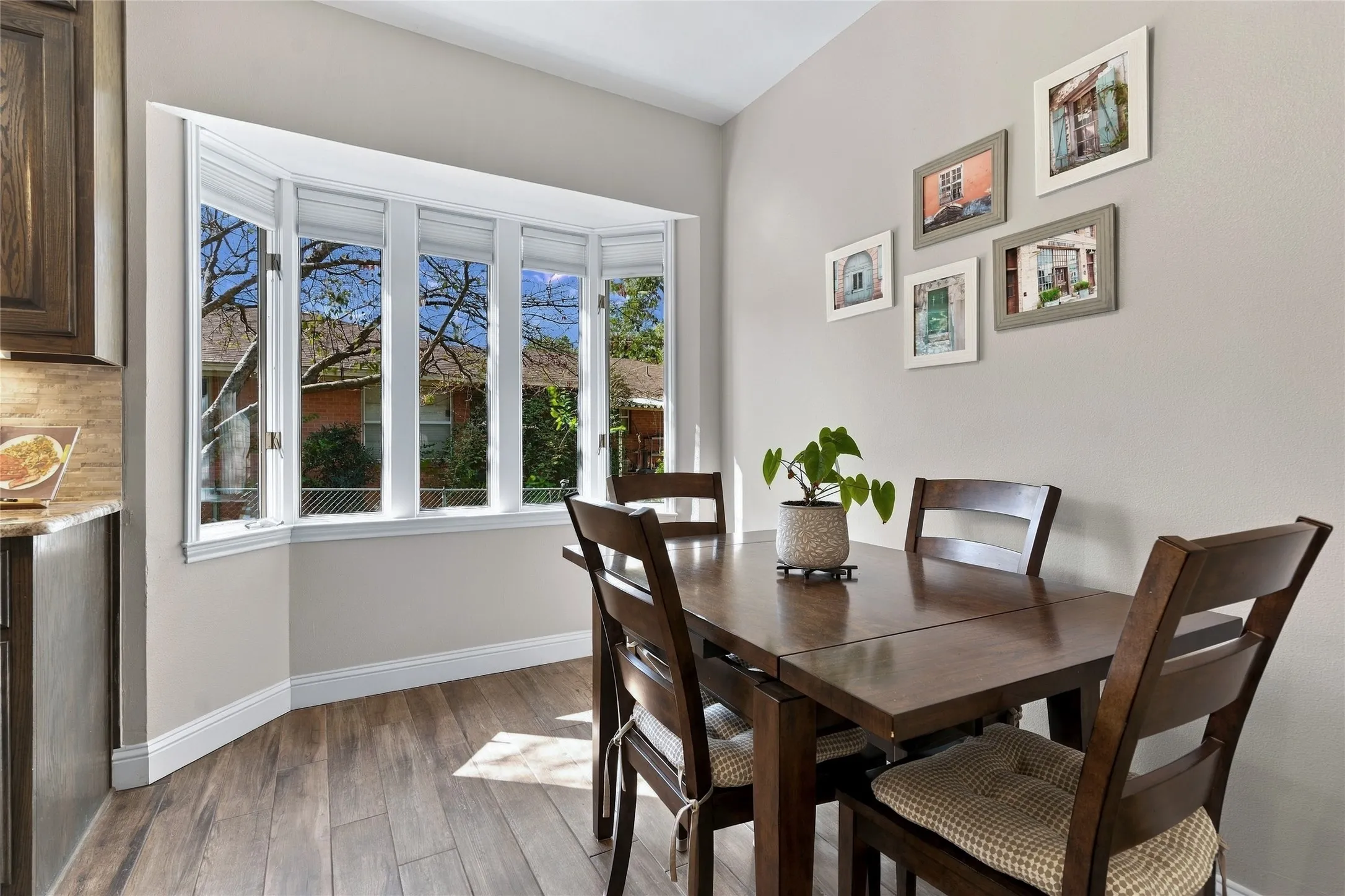 Bay window with multiple panes, wood-finish flooring, and light-toned wall paint