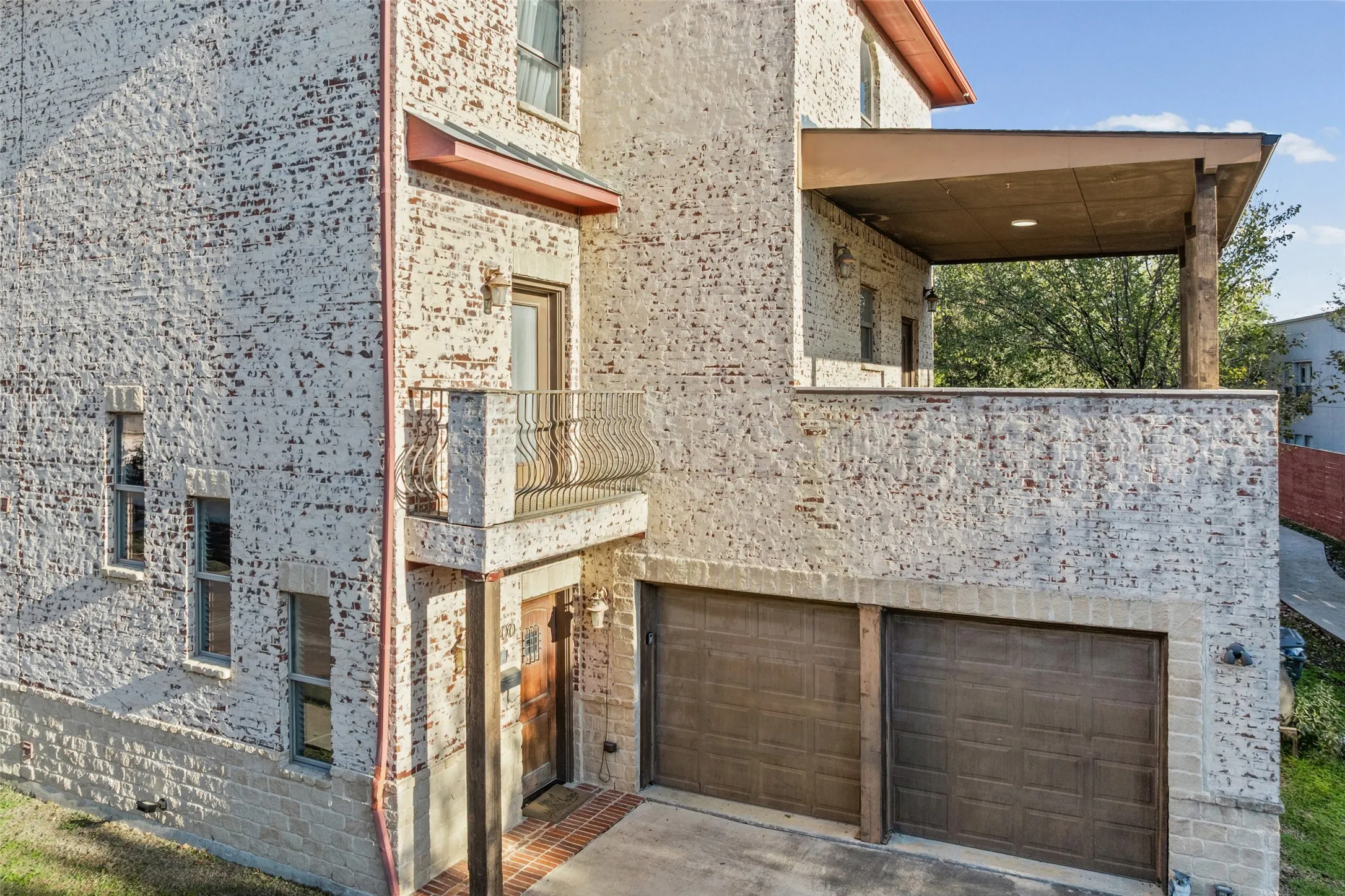 View of large balcony and two car garage